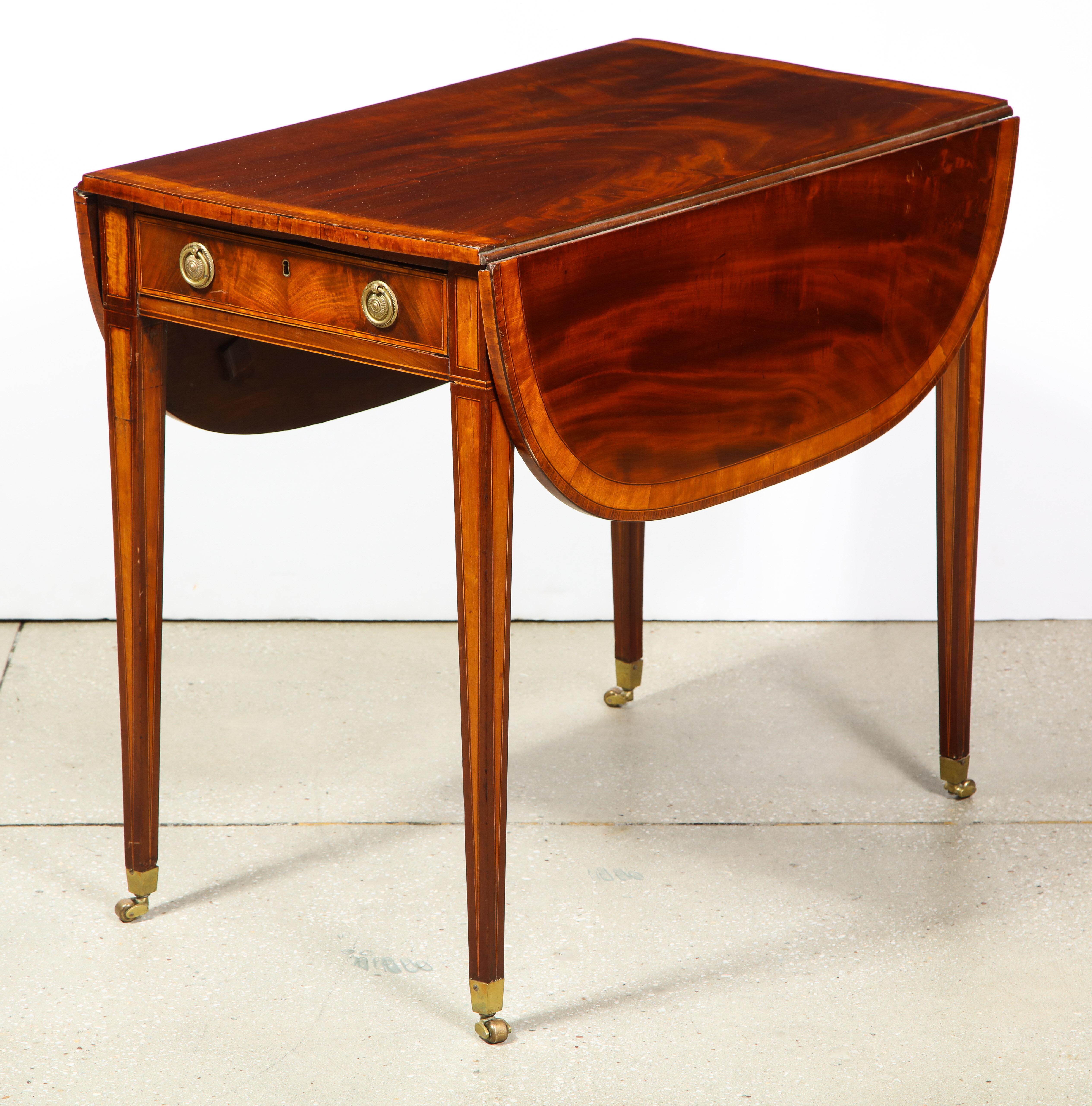 The inlaid mahogany table, with a mahogany top cross banded in satinwood, two 11