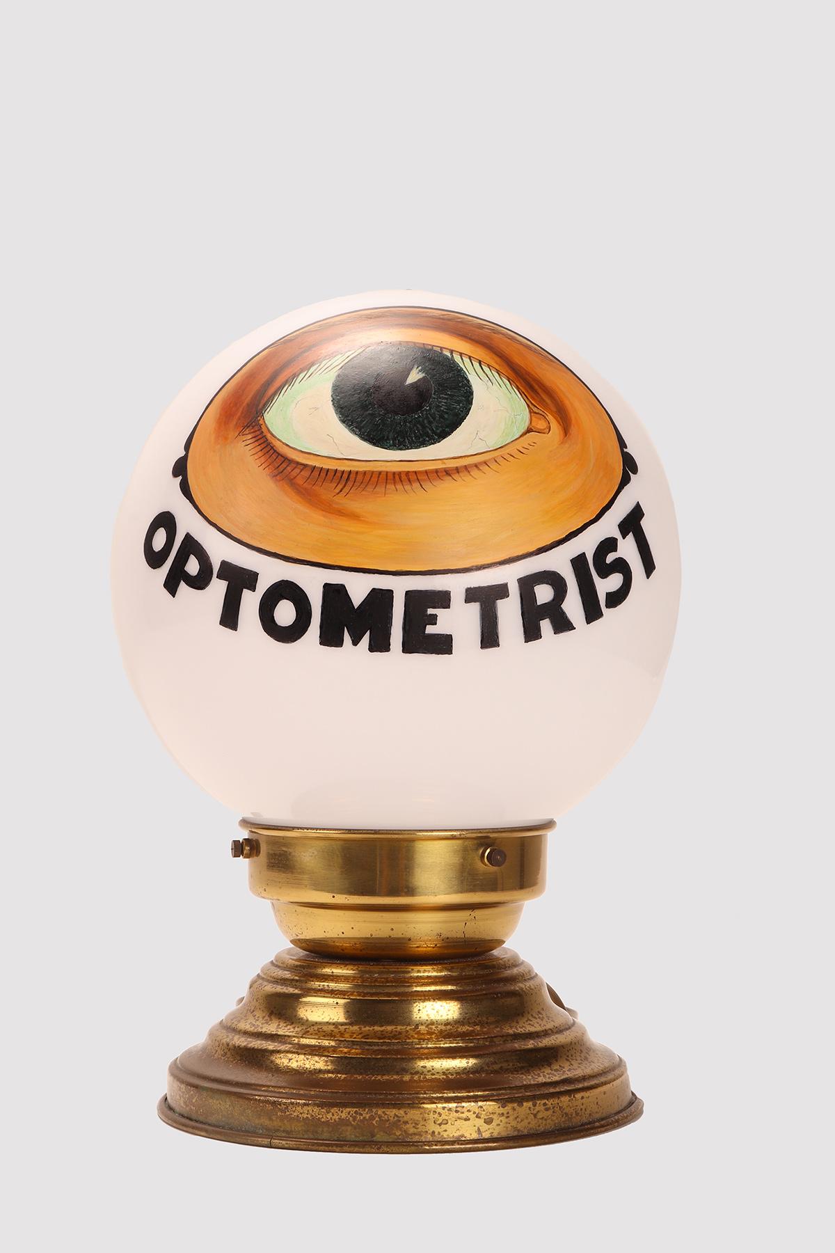 Insegna luminosa a forma di globo per negozio di optometria in celluloide, con occhio dipinto, e supporto di base in ottone. L'impianto elettrico è stato riprogrammato.
Stati Uniti d'America, intorno al 1950.