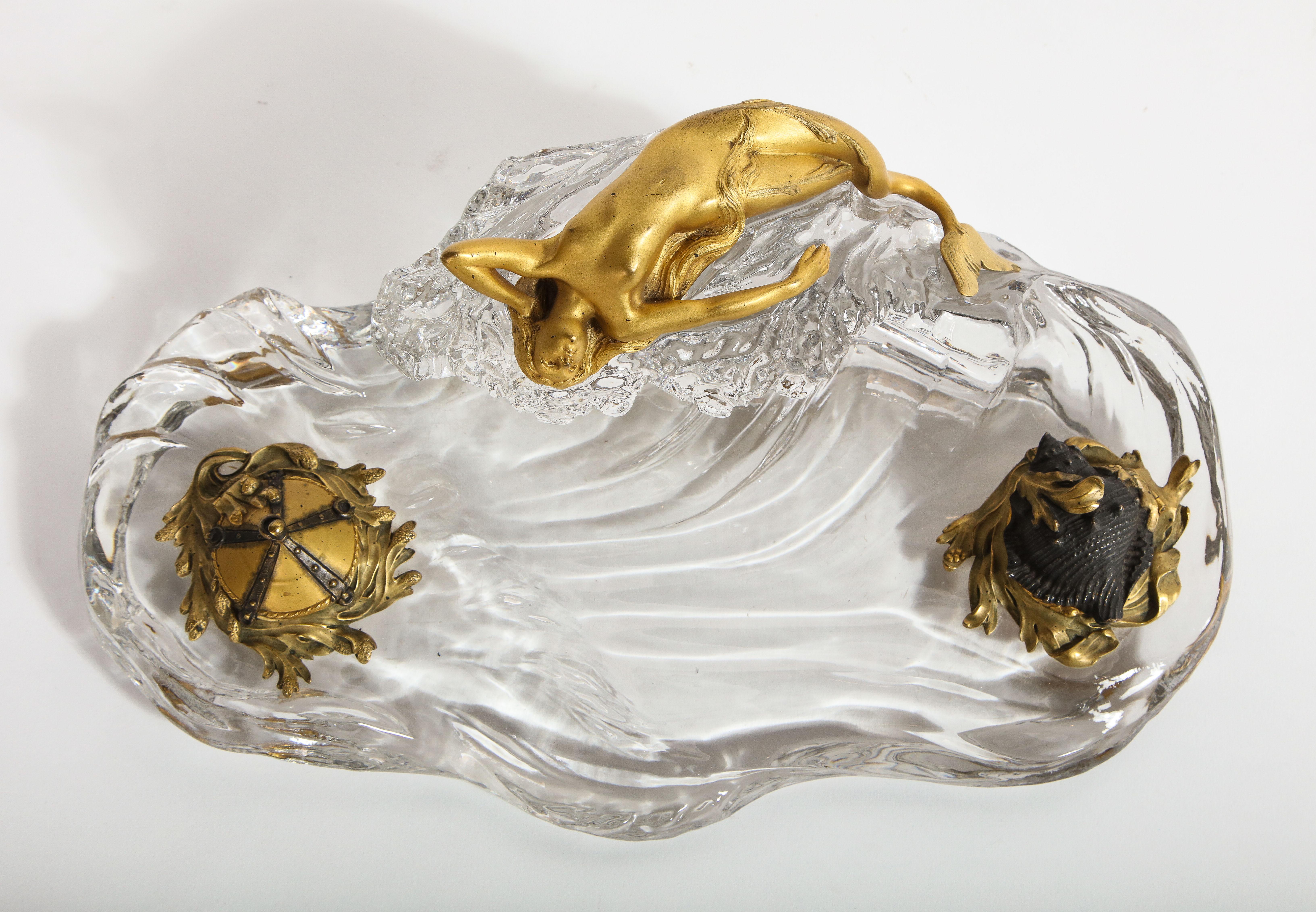 A Rare and Marvelous Signed Baccarat Crystal Nautical Inkwell with a Dore Bronze Maiden and Patinated and Dore Bronze Ink Pots. The body is made up of the finest quality of French hand-carved crystal a doré bronze mermaid sleeping on top of a