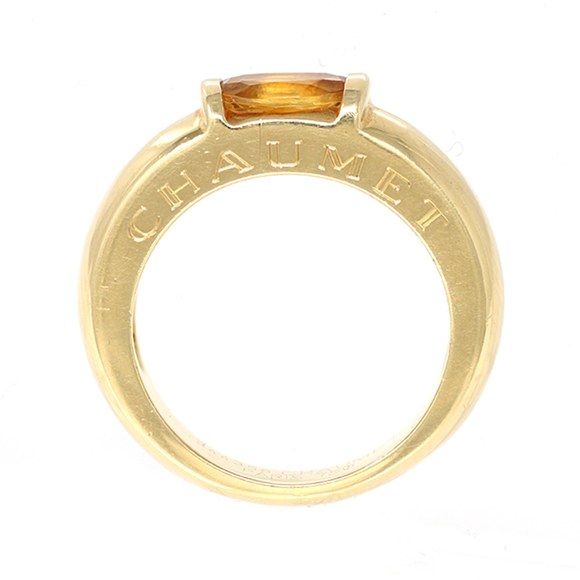 The band ring by the French house of jewelry Chaumet Paris features an oval-shaped citrine set in 18-karat yellow gold. The citrine is tension set and has Chaumet engraved on the side of the shank. The gross weight is 9.8 grams. It fits a size 7 and