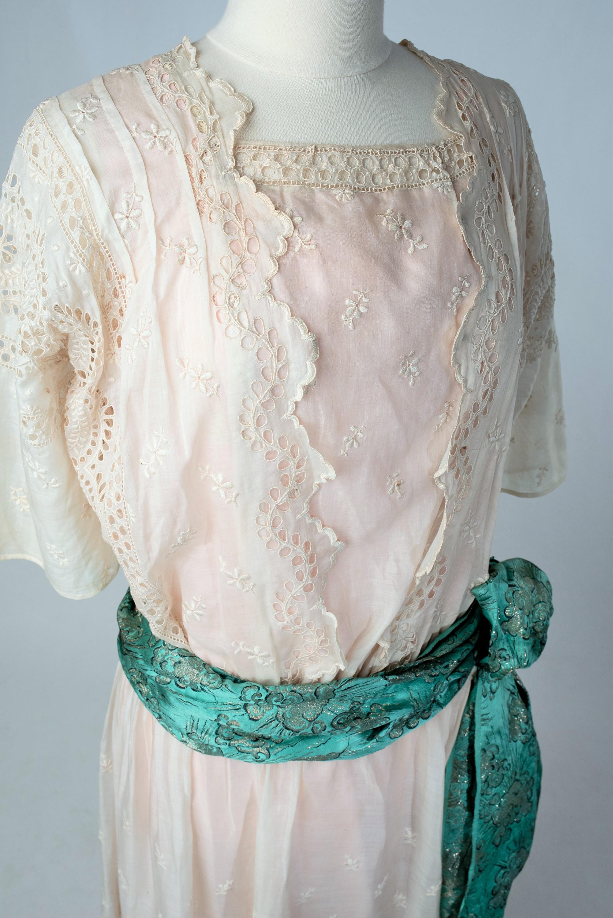 Circa 1918 - 1922
France

Beautiful seaside resort dress for the seaside or the spa in Vichy ! Superb work of broderies anglaise on chiffon silk or ecru silk pongee playing with the transparency of the light pink silk pongee underdress. Straight bag
