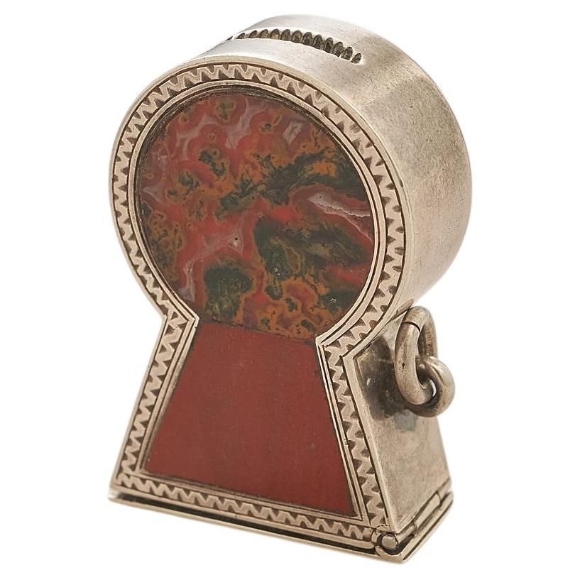 A silver and agate key hole shaped match box
