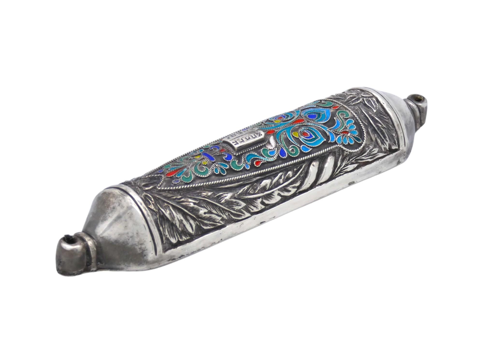 Una splendida custodia per Mezuzah in argento e smalto realizzata da Henryk Winograd negli Stati Uniti nel 1991.

Henryk Winograd (1916-2008) era un maestro argentiere che creava bellissime custodie per mezuzah. Emigrò negli Stati Uniti dalla nativa