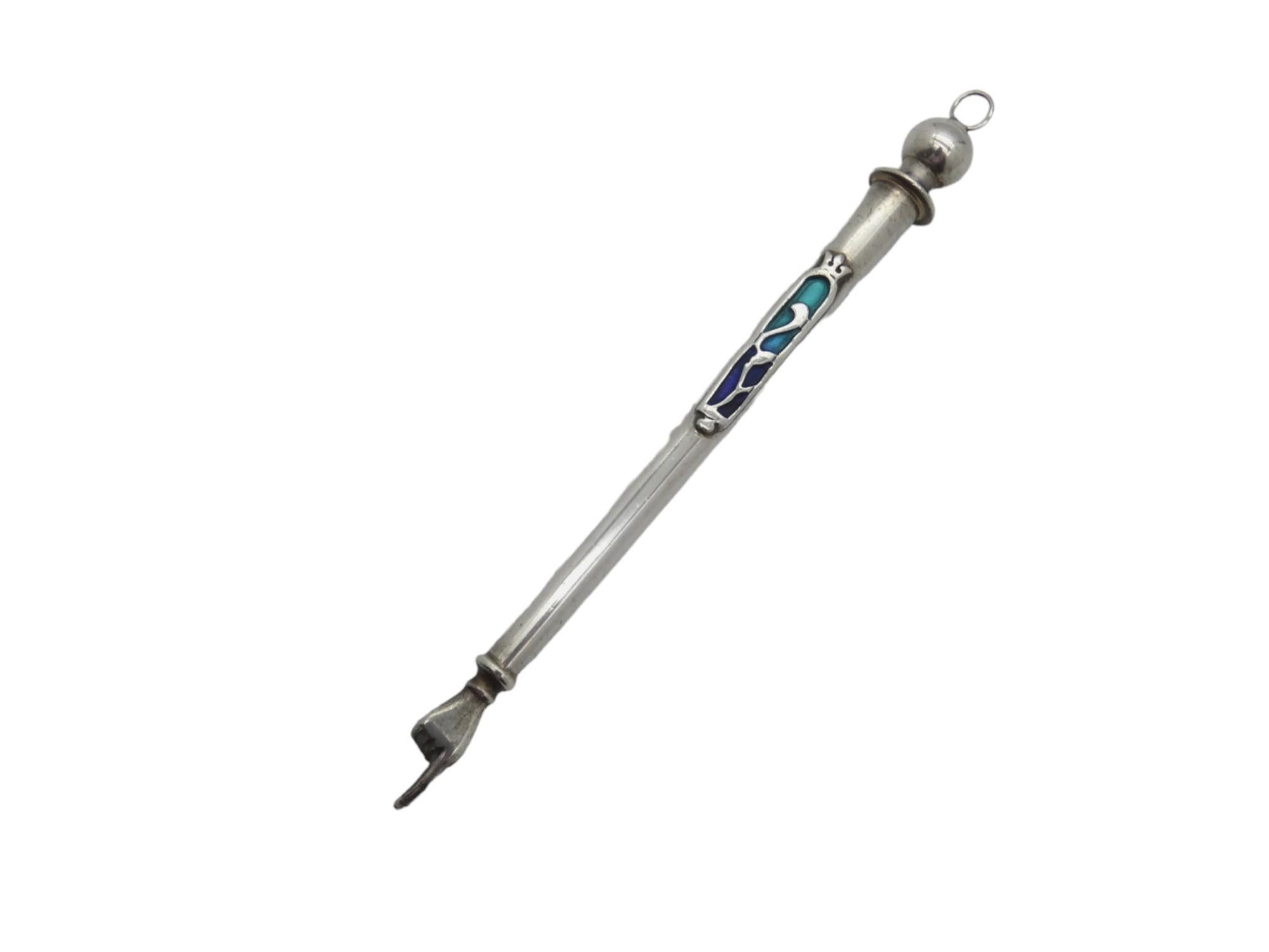A Classic Silver and Enamel Torah Pointer, made in Uzbekistan in the 20th century.

This Torah pointer is classically fashioned with a circular main body a ball finial and a gloved outstretched pointing hand.

Adorning the center of the Torah