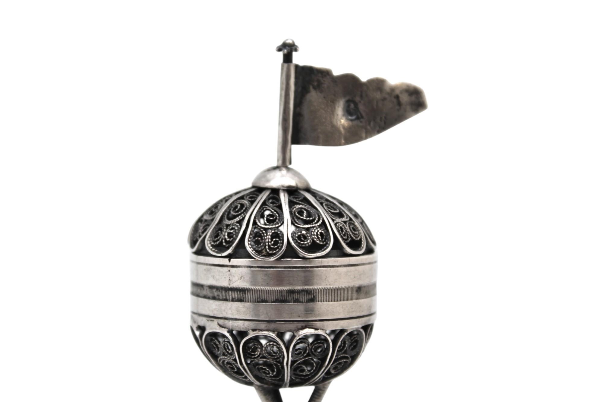 Questo straordinario contenitore per spezie in argento e filigrana, realizzato a Lemberg nel 1814, è un'espressione magistrale dell'arte giudaica dell'inizio del XIX secolo. Disegnato a forma di torre in miniatura, il contenitore poggia su una