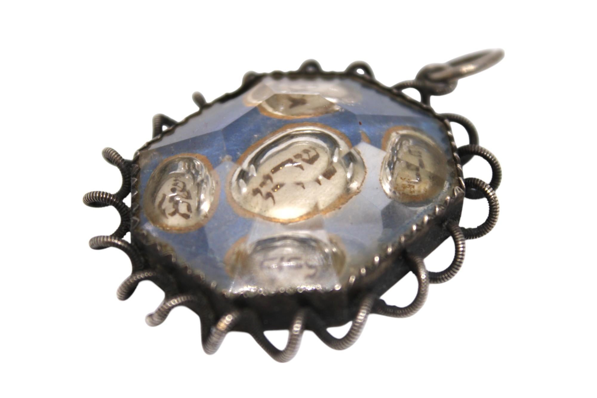 Cet objet judaïque rare et évocateur provient d'Italie et date des XVIIe et XVIIIe siècles. Il incarne un mélange raffiné de symbolisme spirituel et d'artisanat exquis. De forme octogonale, l'amulette est composée d'une enveloppe d'argent dentelée