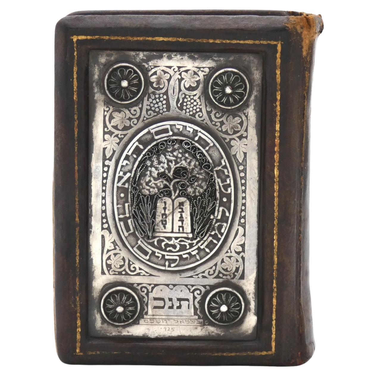 A Silver and Leather Bezalel Book Binding from Israel circa 1940 is a prominent piece of Judaica. Bezalel, the name associated with the Bezalel School of Arts and Crafts in Jerusalem, is known for its significant contributions to Jewish art and