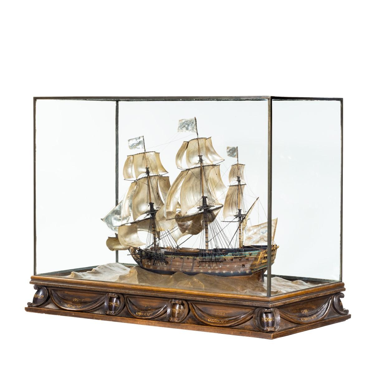 A silver and wood model of HMS Victory by H Wylie, showing ‘Victory’ in her first commission 1780, constructed from ships’ timbers by the artist Harold Wyllie (1880-1973), fully rigged with silver sails over an African oak and ebony hull with
