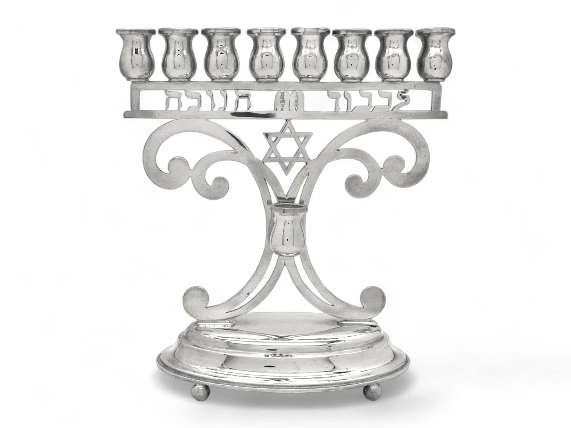 Moderna ed elegante lampada di Hanukkah realizzata all'inizio del periodo moderno del XX secolo in Austria.

La lampada di Hannukah è montata su una base ovale a gradini ben arrotondata, sostenuta da quattro piedi a sfera.

Il corpo principale è