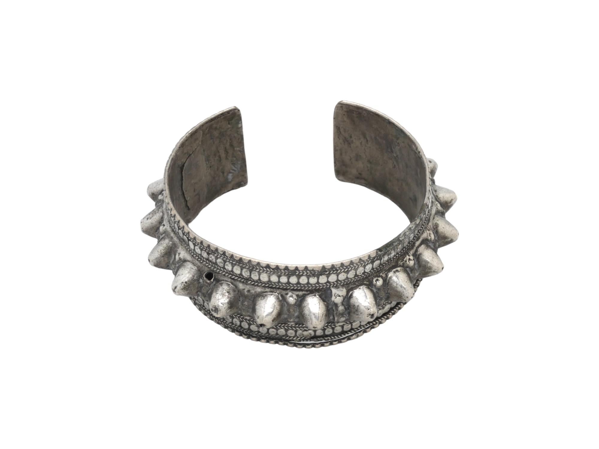 A striking and bold example of traditional Yemeni jewelry, this Silver Band, crafted circa 1900, showcases a rugged and expressive aesthetic characteristic of regional silversmithing. The central feature of the band is a prominent line of thick,