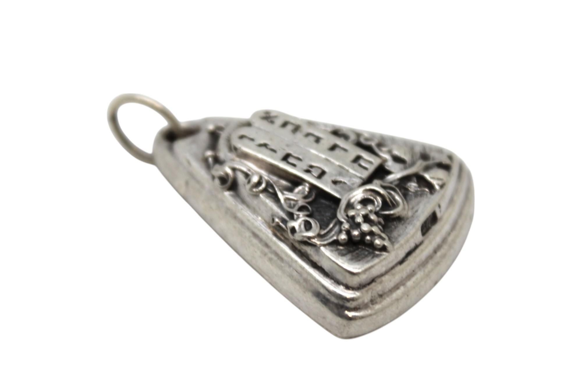 Un sorprendente ciondolo in argento Judaica del famoso artista del repoussé Henryk Winograd, realizzato in un'audace forma triangolare a gradini, solida e pesante, che dimostra la distinta tecnica del repoussé e l'intricata lavorazione a mano di