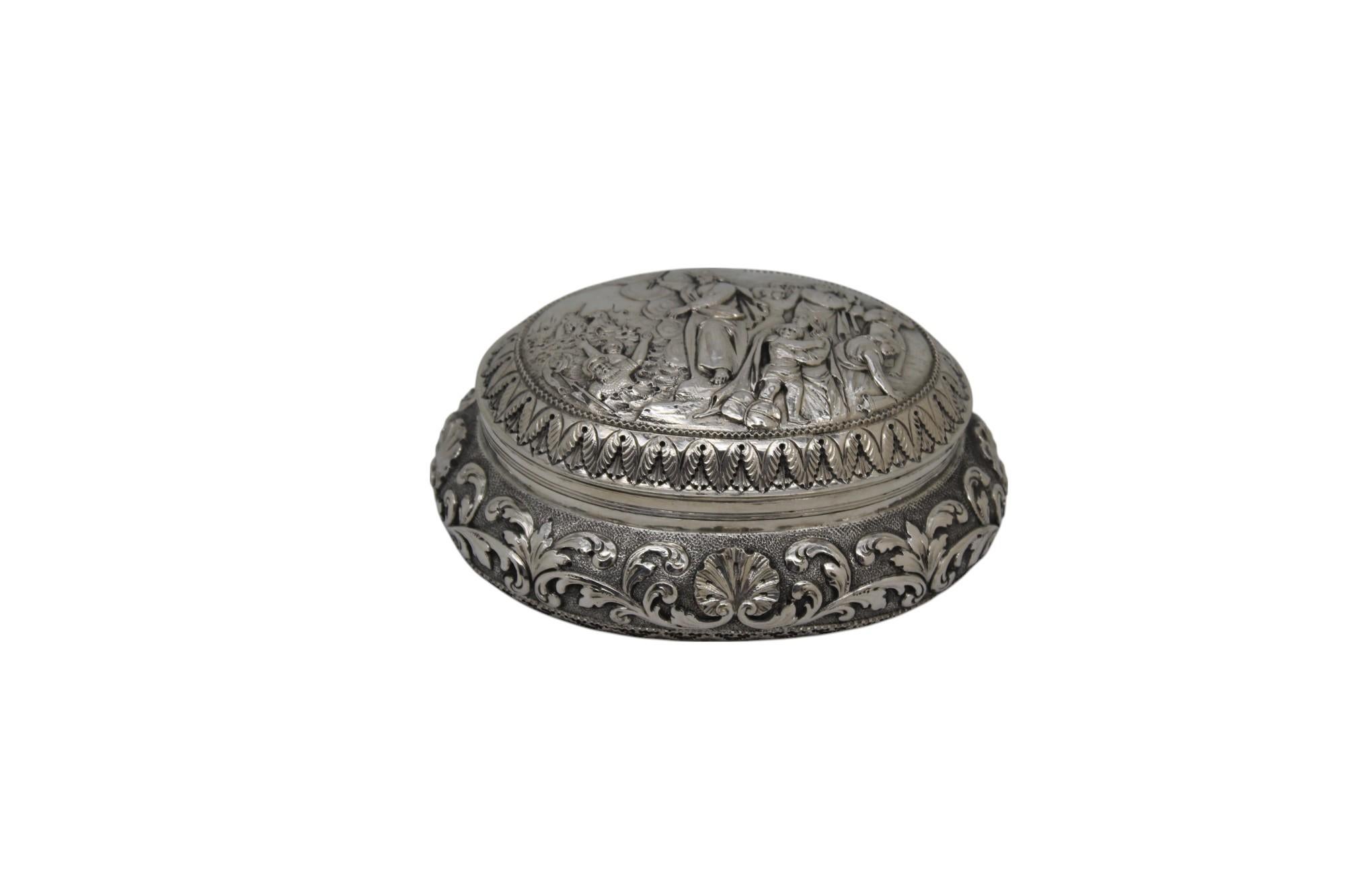 Diese bemerkenswerte holländische Silber-Etrog-Dose, die um 1900 in den Niederlanden hergestellt wurde, ist ein großartiges Beispiel für raffinierte Judaica in Verbindung mit dramatischer Erzählkunst. Das ovale Kästchen mit seiner großzügigen,