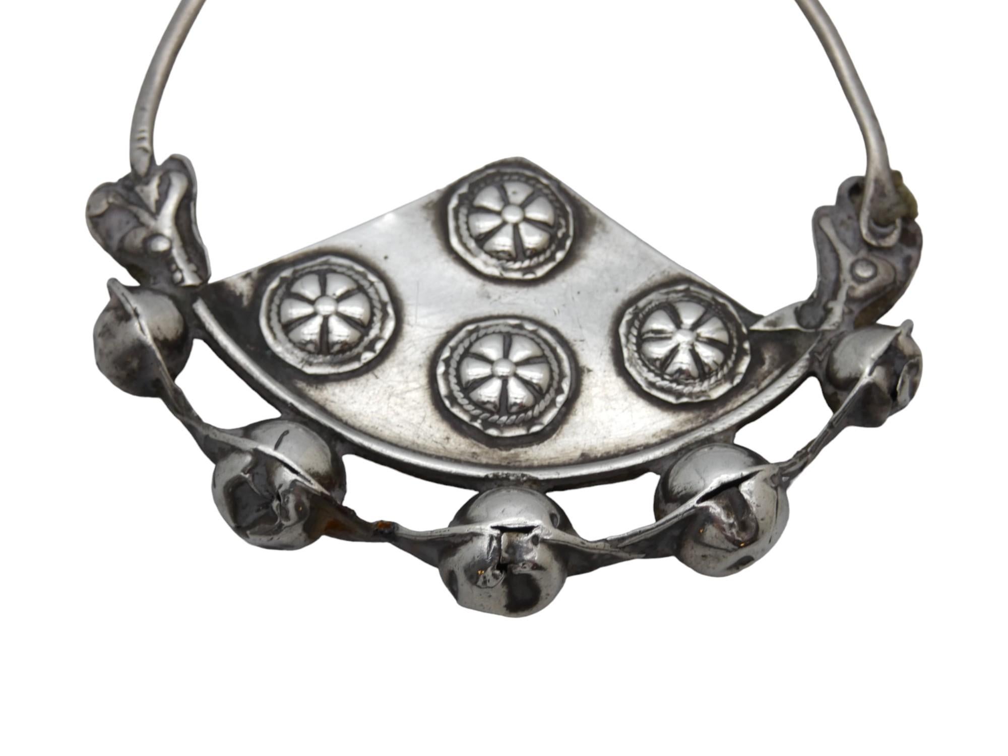 Questo elegante orecchino d'argento, realizzato nella regione del Caucaso (Kavkaz) intorno al 1900, è un esempio straordinario di gioielleria regionale, che combina forme scultoree e dettagli delicati in uno stile decisamente