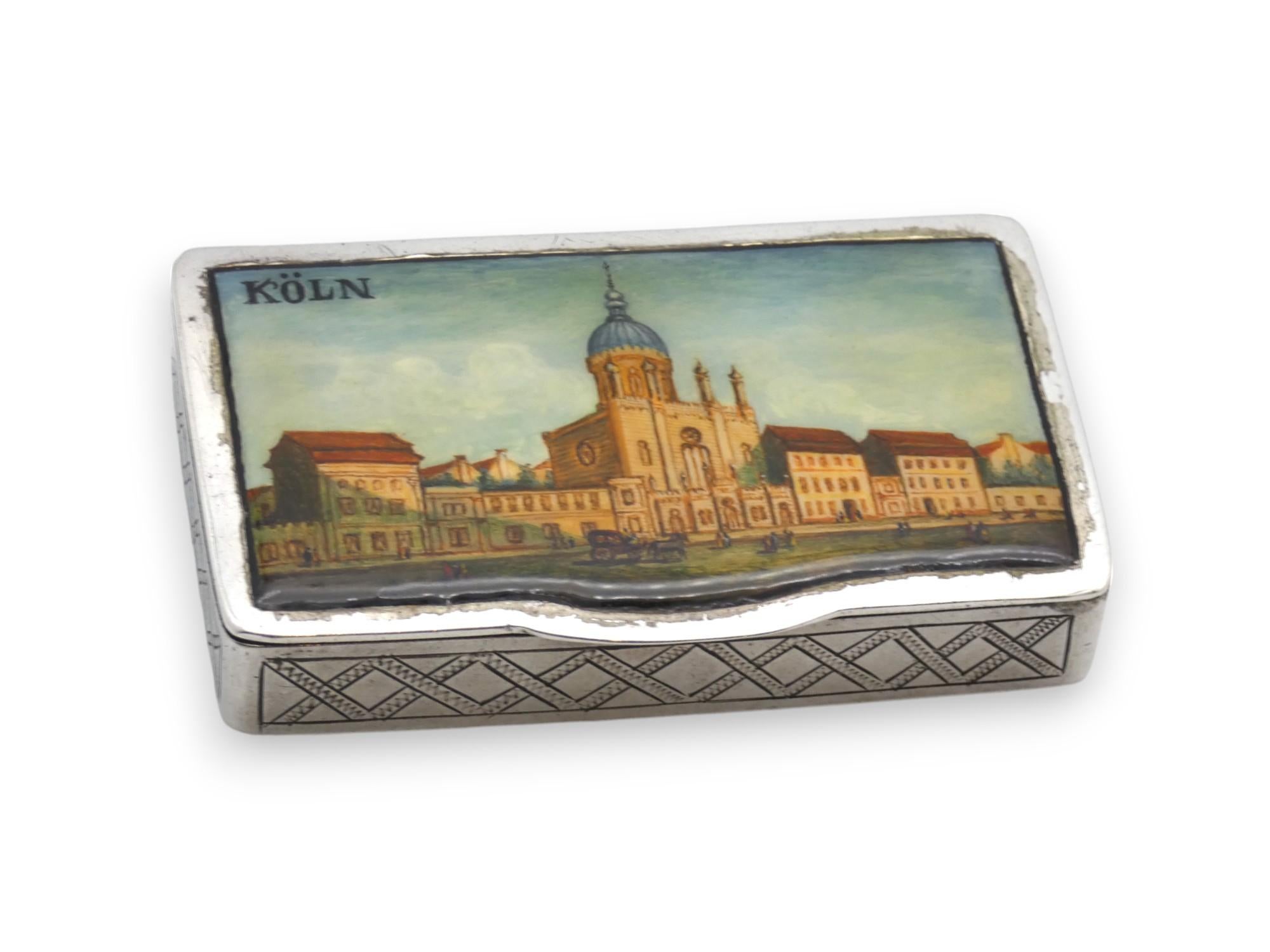 Tabatière unique en argent et en émail représentant la synagogue de Cologne, fabriquée en Allemagne au XIXe siècle.

Cette superbe tabatière est de forme rectangulaire, le couvercle à charnière est émaillé d'une vue colorée de la majestueuse