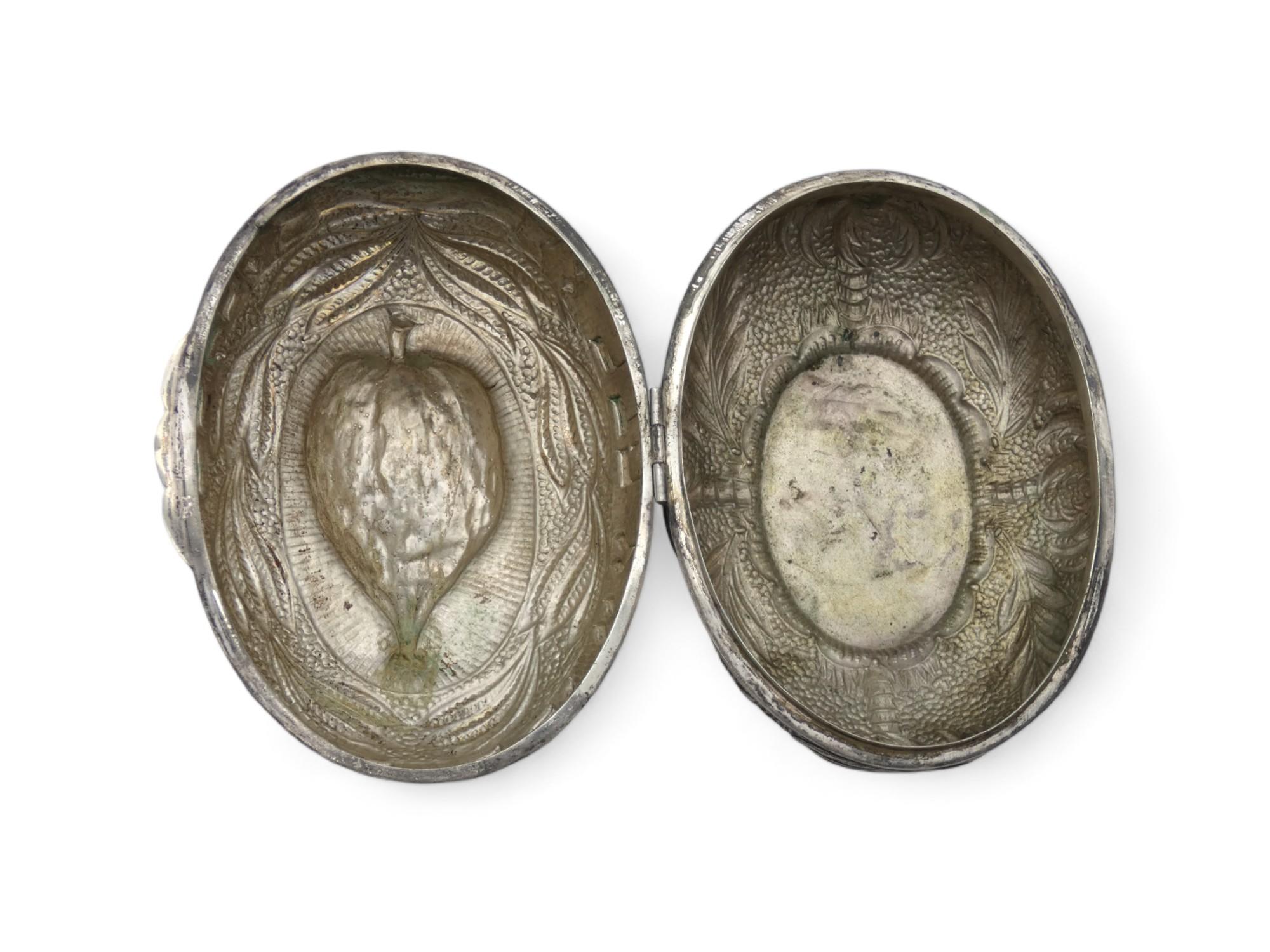 A Stunning Silver Etrog Container, made in Hungary Around the 1900's.

Hammered and chased Etrog shape is embellished at top of the container on a background of lined circular scrolling.

The sides of the upper cover are adorned with beautifully