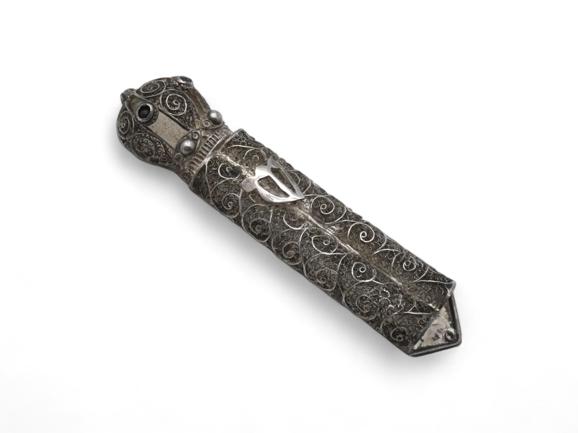Un insolito astuccio per Mezuzah in filigrana d'argento realizzato in Israel, circa 1950.

Custodia per Mezuzah molto insolita, realizzata quasi interamente in filigrana a forma di alto rotolo della Torah con una corona applicata sulla parte