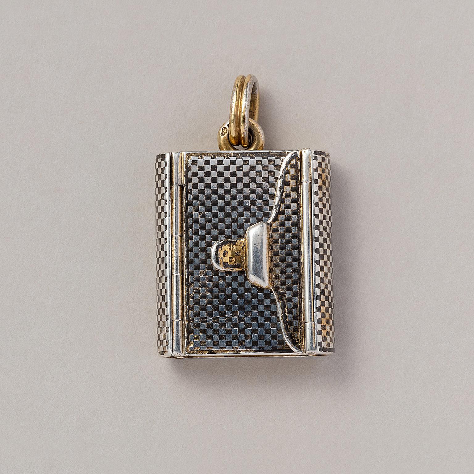 A silver gilt and niello locket in the shape of an envelope or book, with four compartments, France, circa 1880.
dimensions: 3.2 x 2.2 cm
weight: 16.68 grams 
