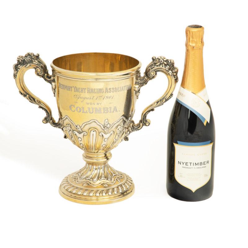 A silver gilt Newport Yacht Racing Association won by Columbia, 1901. This silver-gilt trophy is a two-handled ‘loving cup’ with a gilded interior and flowerhead adorned scroll handles.  The lower body and foot have repoussé spiral gadrooning and