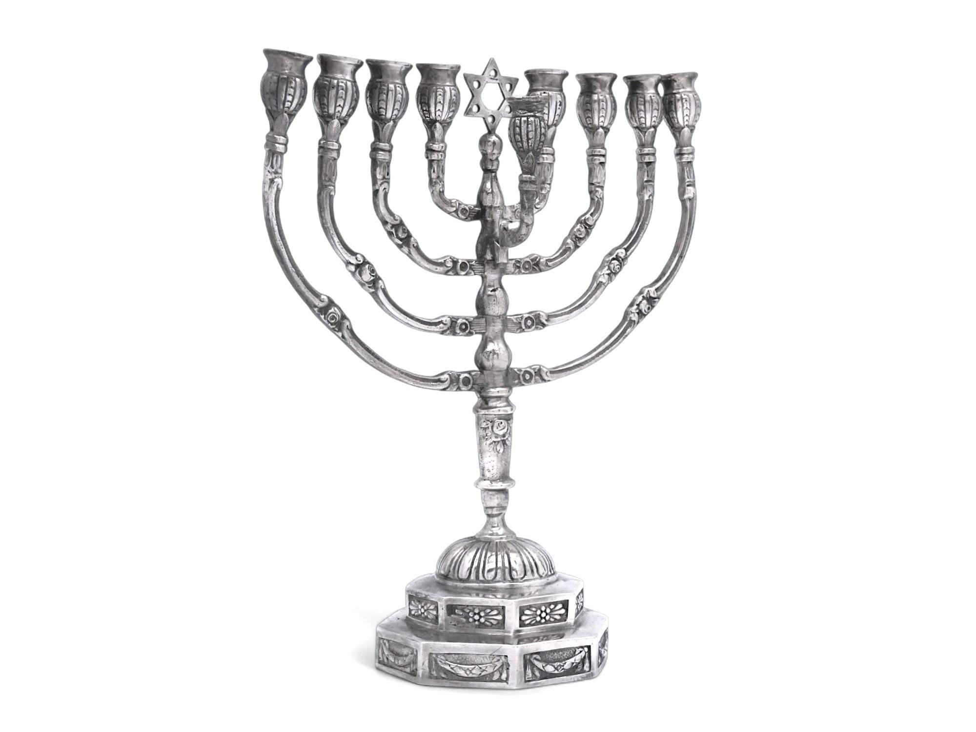 Charming German silver Hanukkah Menorah cast at the beginning of the 20th century.

Menorah rests on an octagonal bi-stepped base embellished with floral and foliate drapery decorations at its sides.

A gadroon-styled dome is mounted atop the base