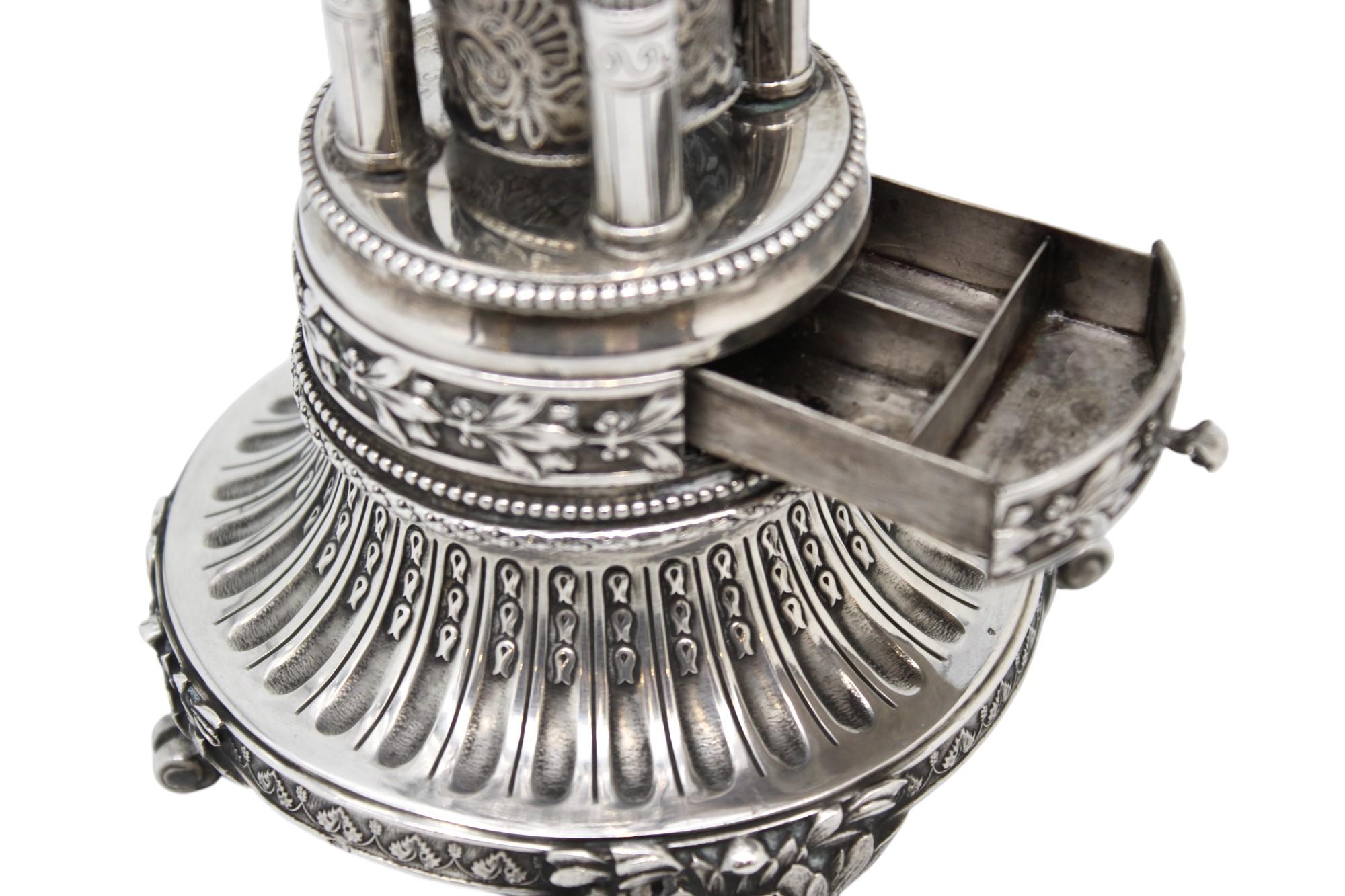 Questo straordinario compendio per Havdalah in argento, attribuito al famoso argentiere del XX secolo Peter Ehrenthal, è un capolavoro dell'arte cerimoniale e dell'artigianato ebraico. Ricco di dettagli e d'ispirazione architettonica, il pezzo