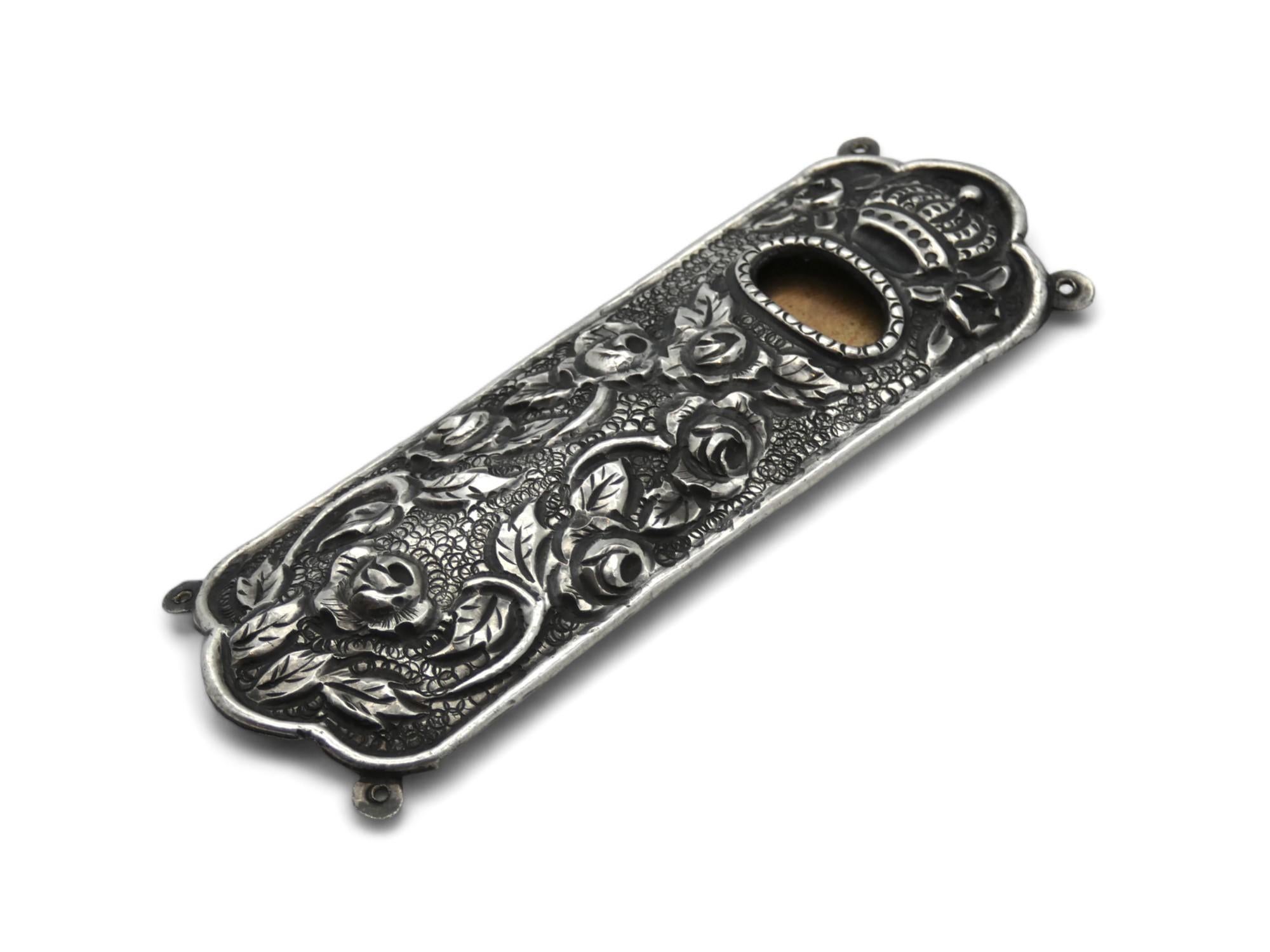 Uno splendido astuccio per Mezuzah in argento realizzato in Italia nel 1900 circa. 

Le custodie per mezuzah italiane del 1900 sono particolarmente rare da trovare e quelle che si trovano sono meravigliose e preziose.

Il coperchio esterno di questo
