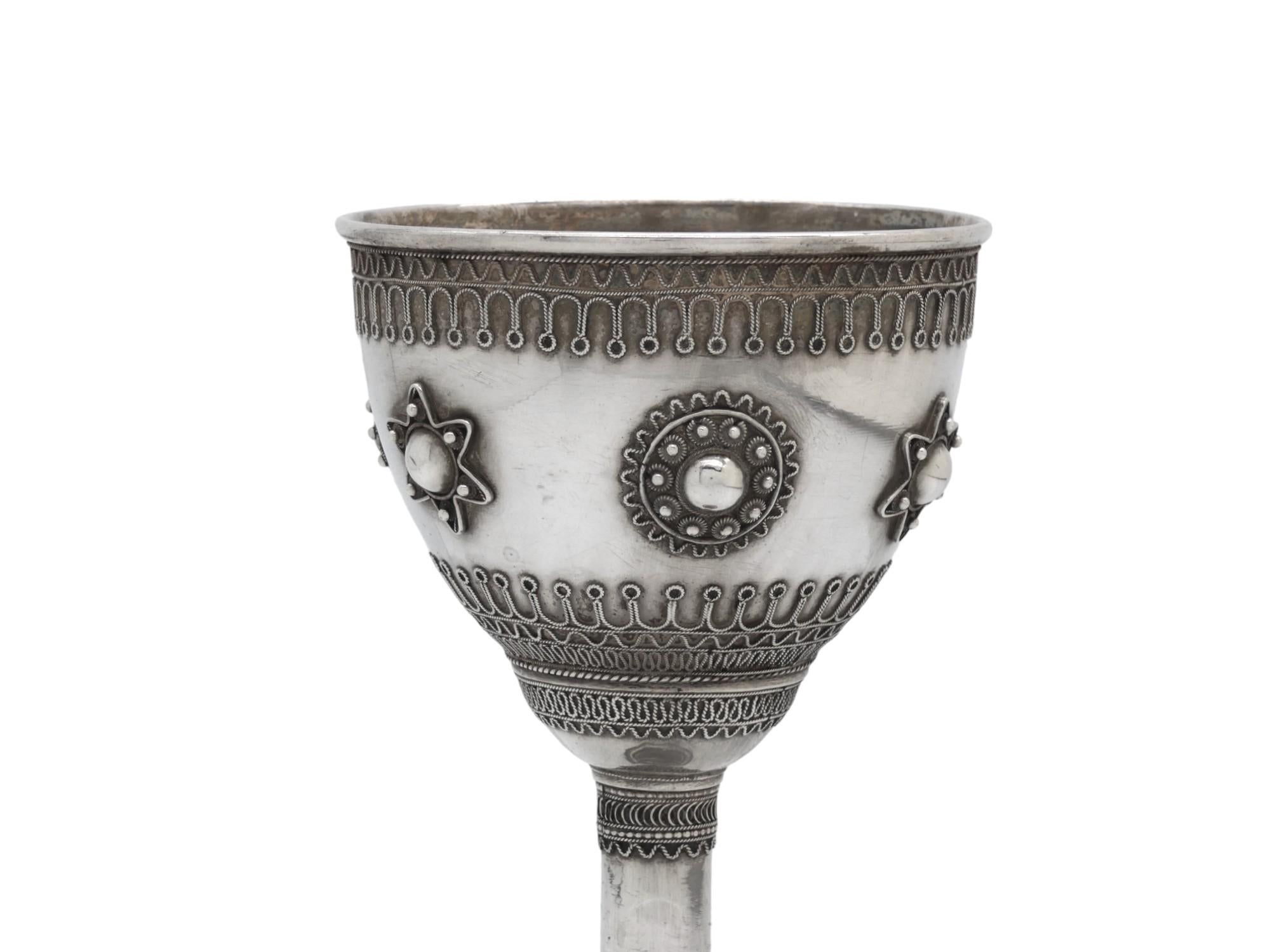 Questo calice Kiddush in argento di Gerusalemme del 1950 circa, decorato con intricati disegni in filigrana, è un pezzo di Judaica prezioso e culturalmente significativo. 

Lo stile e i motivi della filigrana impressa su questo calice ricordano il