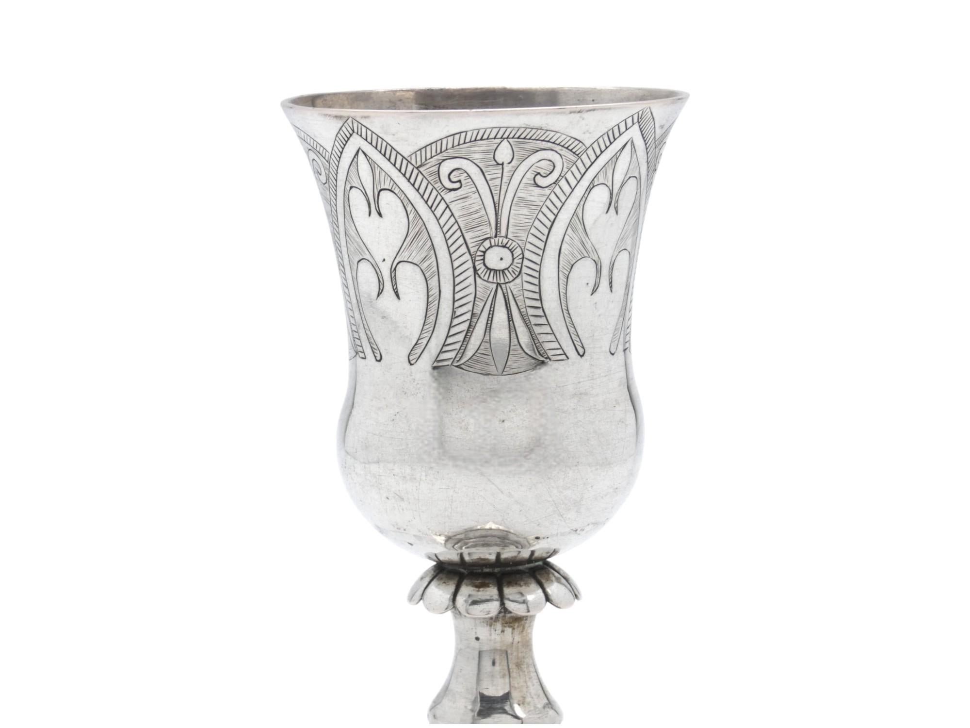 Un elegante calice da Kiddush in argento, realizzato in Polonia nel XIX secolo

Questo calice ha un design più elaborato rispetto alla maggior parte dei calici Kiddush provenienti dalla Polonia. I motivi fogliati incisi sul corpo principale