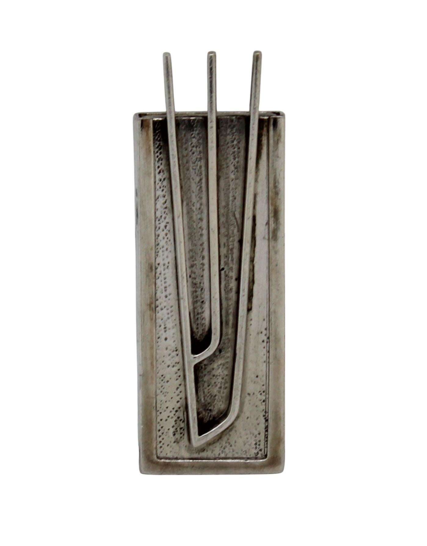 This elegant silver mezuzah case, attributed to renowned Israeli silversmith David Heinz Gumbel, exemplifies his signature modernist approach. The case features a square design with a large prominent, sculptural Hebrew letter 