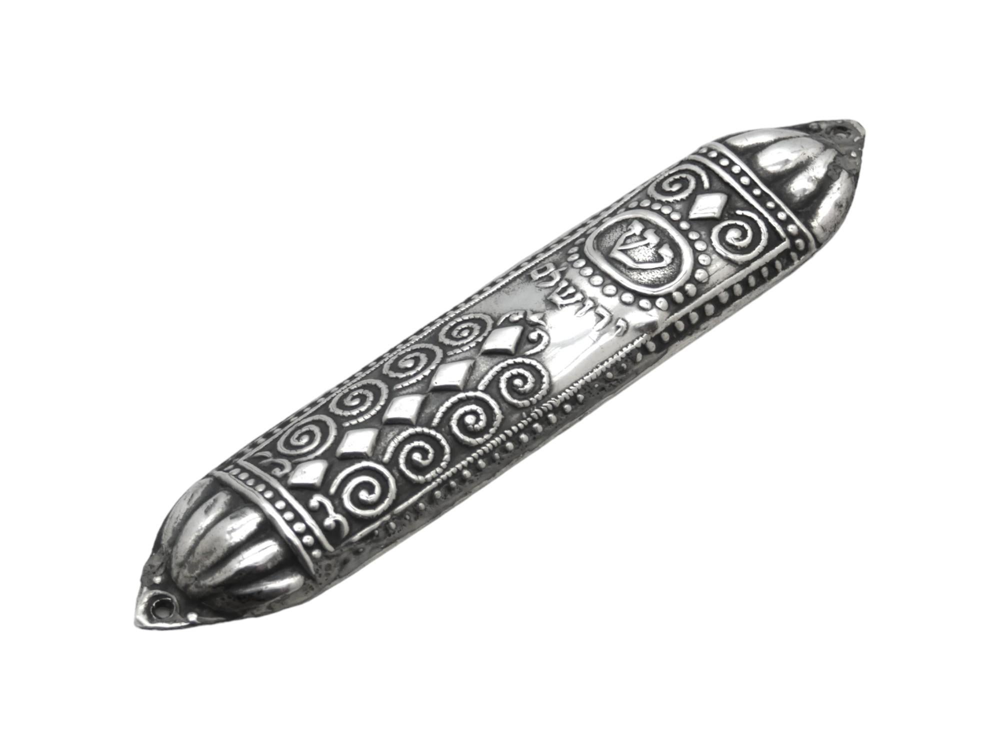 Una custodia per mezuzah in argento realizzata da Bezalel a Gerusalemme intorno al 1920 è un pezzo importante di Judaica, che rappresenta una fusione tra i motivi tradizionali ebraici e il design dei primi anni del XX secolo. La Bezalel Art School