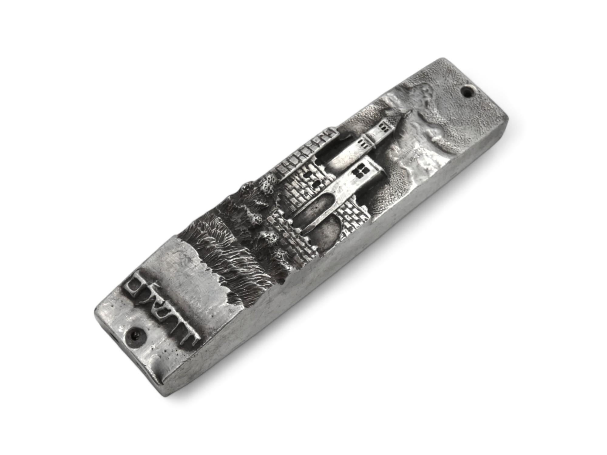 Una custodia per Mezuzah in argento realizzata da Henryk Winograd a New York nel 1991.

Henryk Winograd (1916-2008) era un maestro argentiere che creava bellissime custodie per mezuzah. Emigrò negli Stati Uniti dalla nativa Polonia nel 1972 e iniziò