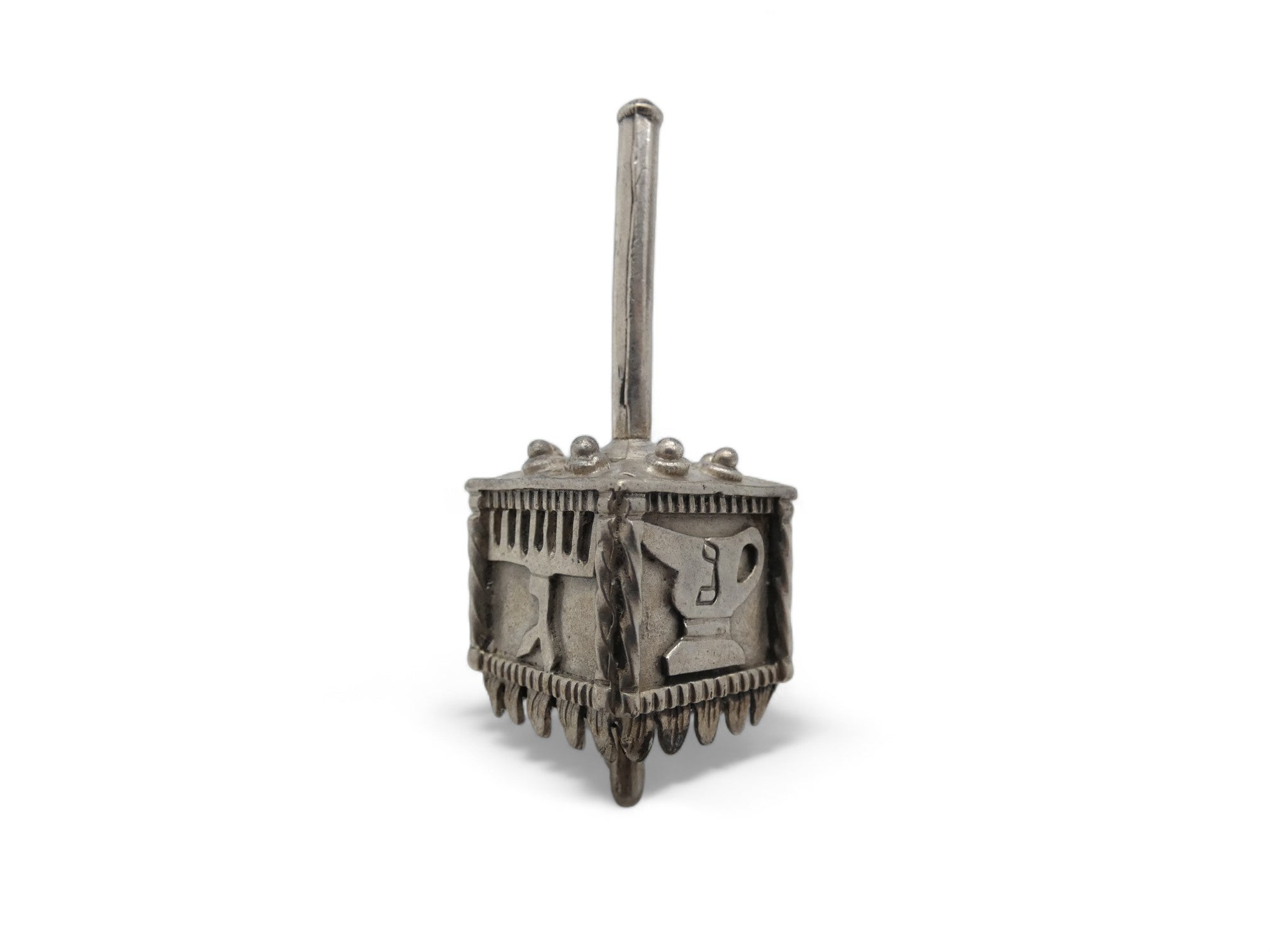Un Dreidel moderno in argento realizzato nel XX secolo.

Questo Dreidel moderno in argento è di fattura insolita. I lati del dreidel sono quadrati e le lettere ebraiche Nun, Gimmel, Hey e Shin sono ben visibili, ma i punti in comune si fermano qui.