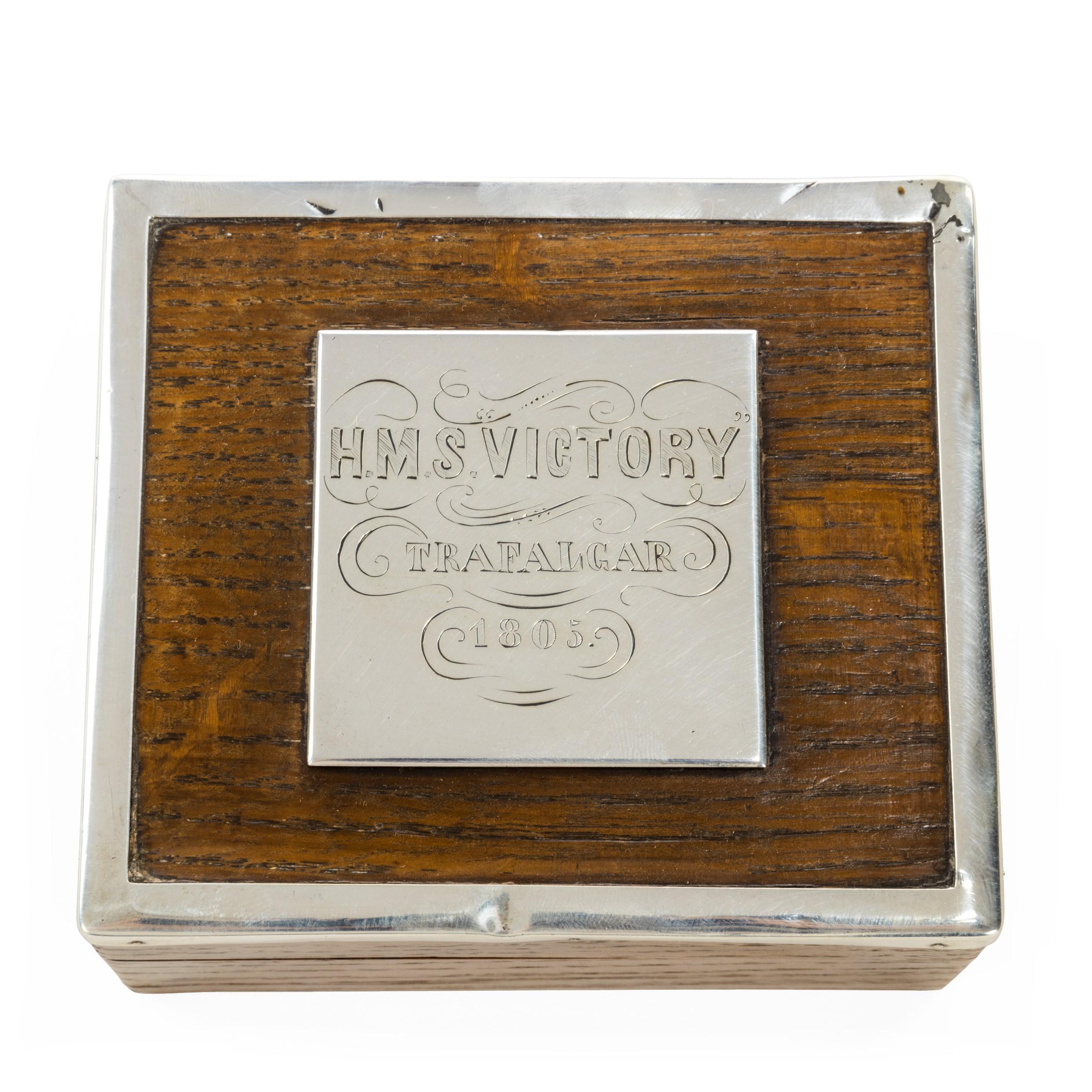 A silver mounted commemorative box made from ‘Victory’ oak, the hinged lid bearing a silver plaque on the outside stating ‘HMS Victory, Trafalgar, 1805’ and another on the inside reading ‘J.E.B. Gordon Highlanders from G.T.H.B. HMS Alexandra, Malta