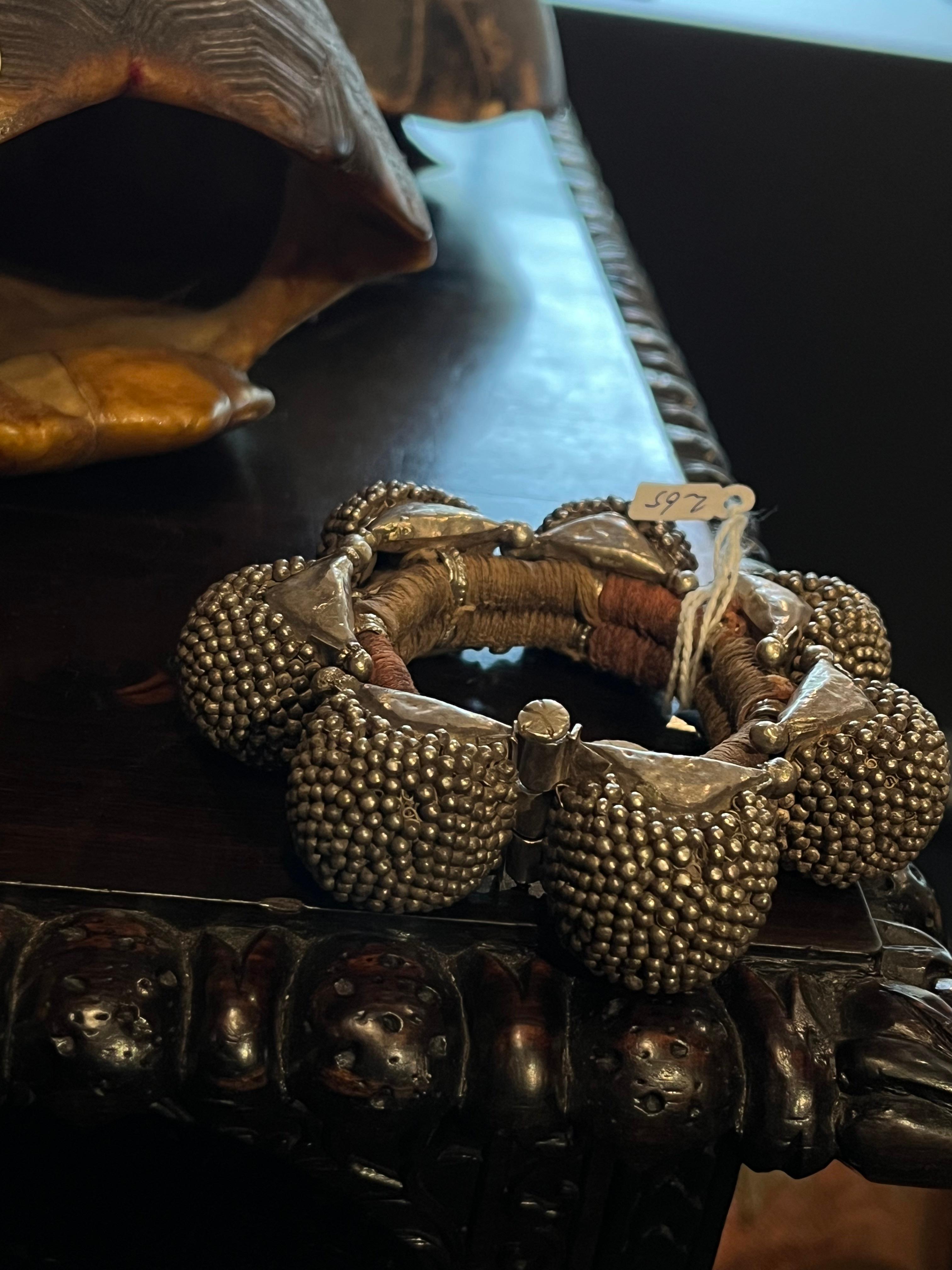 Rajasthan, India, early 20th century

Called 'Naugari' these bracelets were worn by farmer's wife.
The eight 'gajre' balls attached to the central ring are made from a thick piece of silver.

Provenance: 
- Collection Rinck Hollnberger, Munich