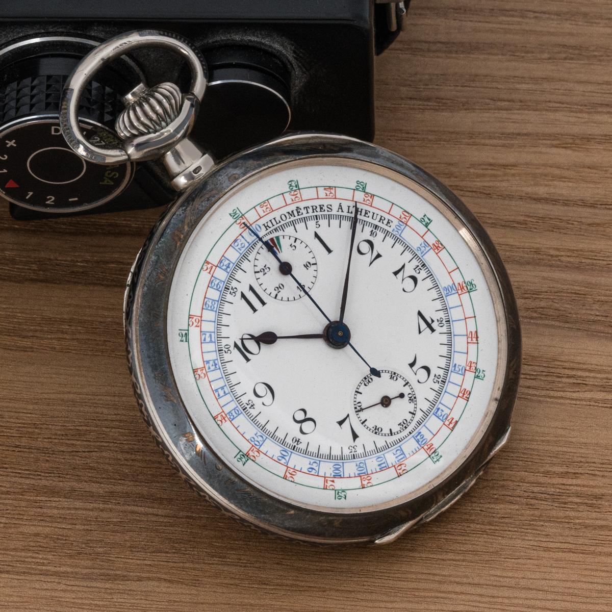 A Silver Niello Open Face Keyless Lever Chrongraph Pocket Watch C1900.

Dial: The superb white enamel dial with tachymeter measuring the speed in kilometers per hour written in French. The colours of Blue, Red and Green in descending order of