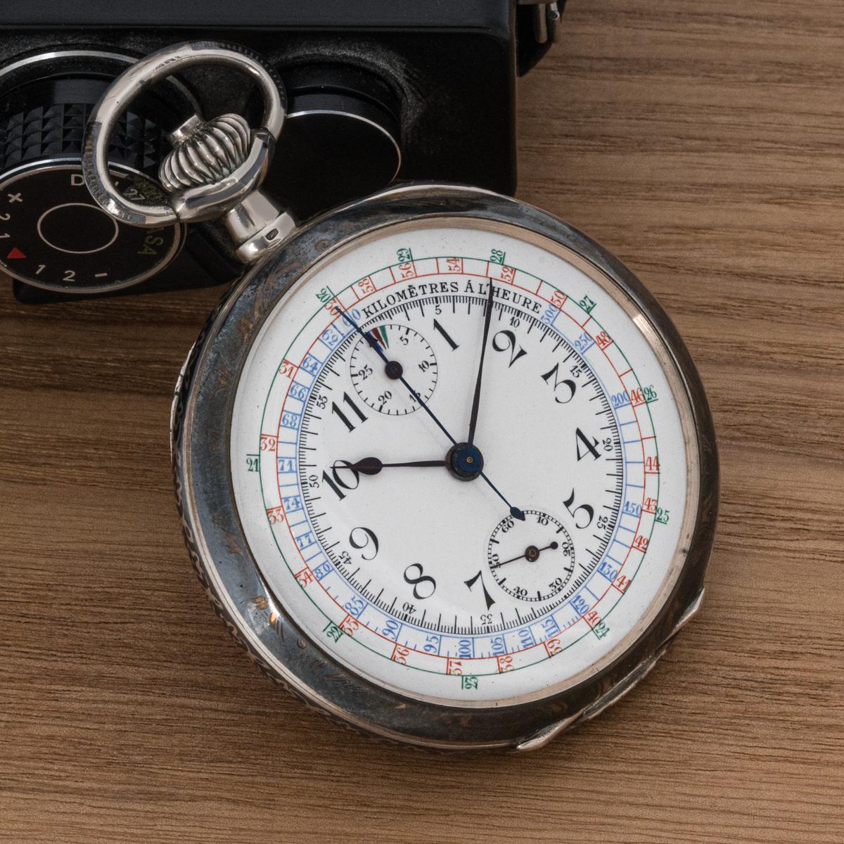 A Silver Niello Open Face Keyless Lever Chrongraph Taschenuhr C1900.

Zifferblatt: Das prächtige weiße Emailzifferblatt mit Tachymeter misst die Geschwindigkeit in Kilometern pro Stunde in französischer Sprache. Die Farben Blau, Rot und Grün in