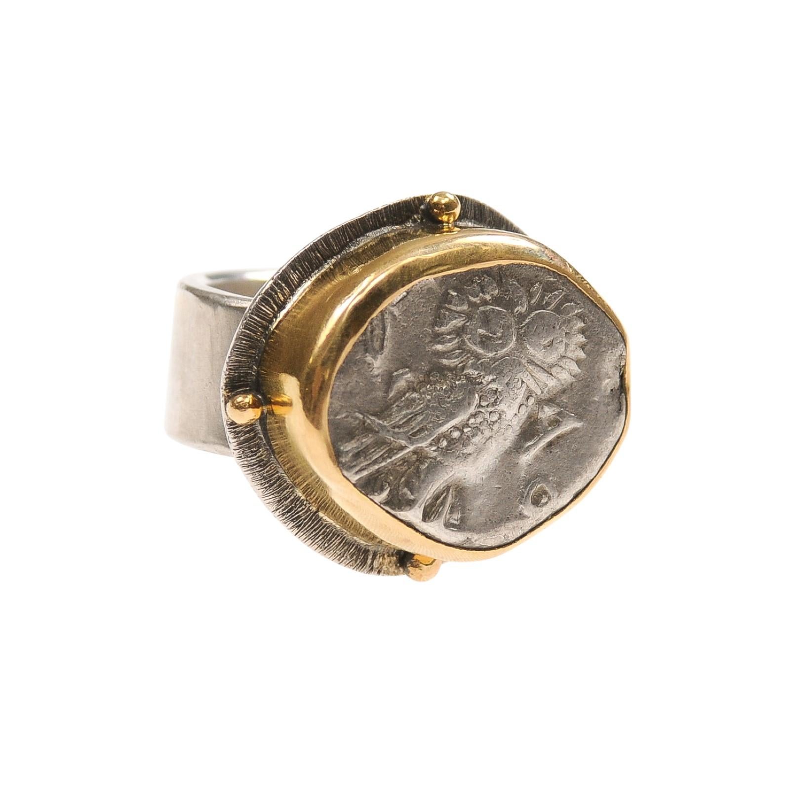 A silver tetradrachm [coin] owl and Athena coin ring trimmed with 22 karat gold. This ancient coin was minted in Attica, Athens, circa 350-300 BC. The diameter of this original coin is 22.55 mm, and has a weight 17.09 grams. On the obverse side, the
