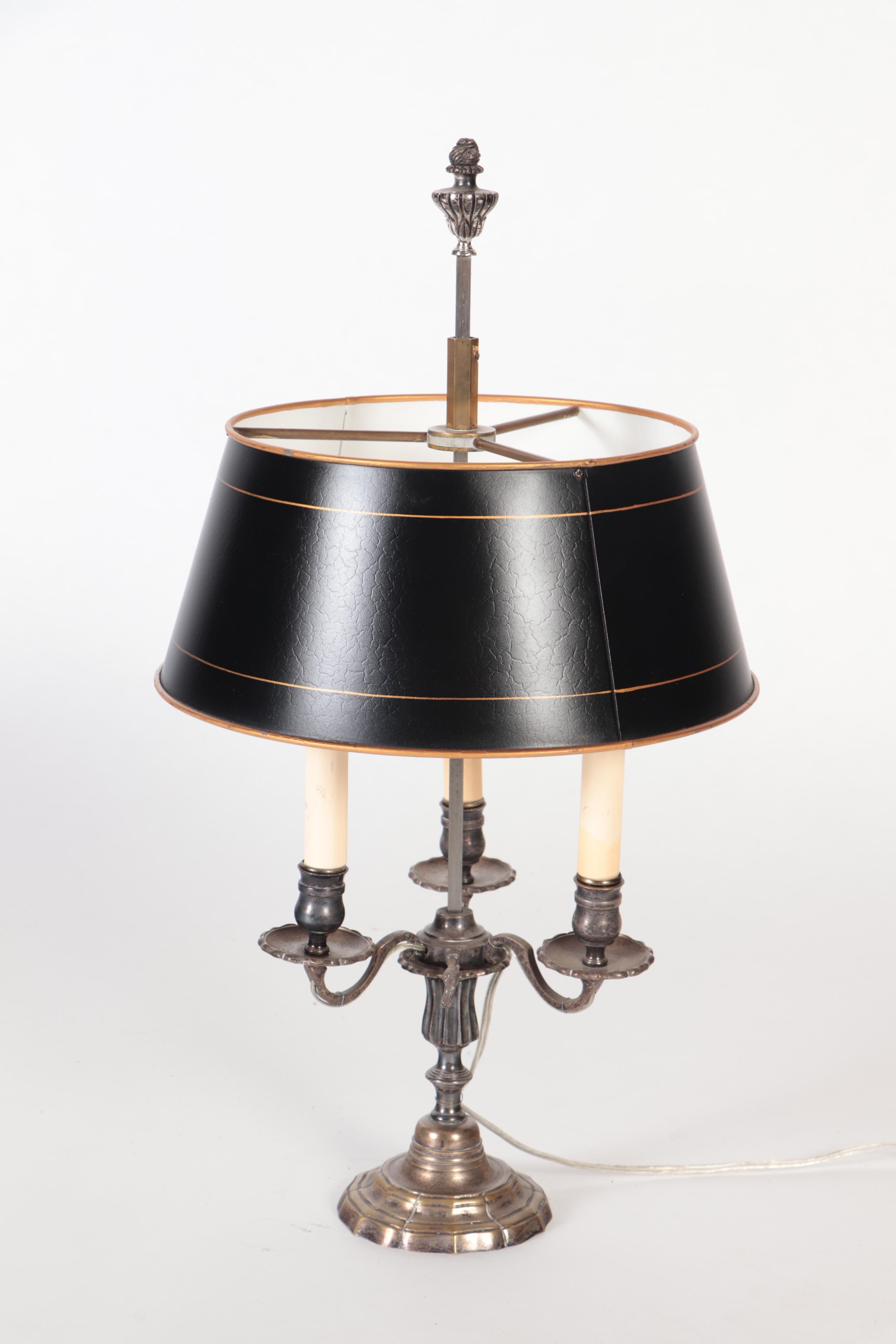 A silver plate Louis XVI style three branch Bouillotte lamp with a tole shade, circa 1900.