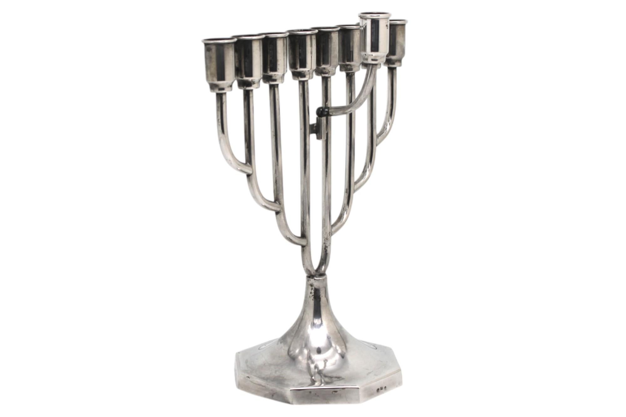 Questa elegante menorah polacca per l'Hanukkah è una straordinaria incarnazione del design minimalista infuso con una riverenza senza tempo. Realizzato in argento lucido, le sue linee pulite e geometriche trasmettono una tranquilla raffinatezza. La