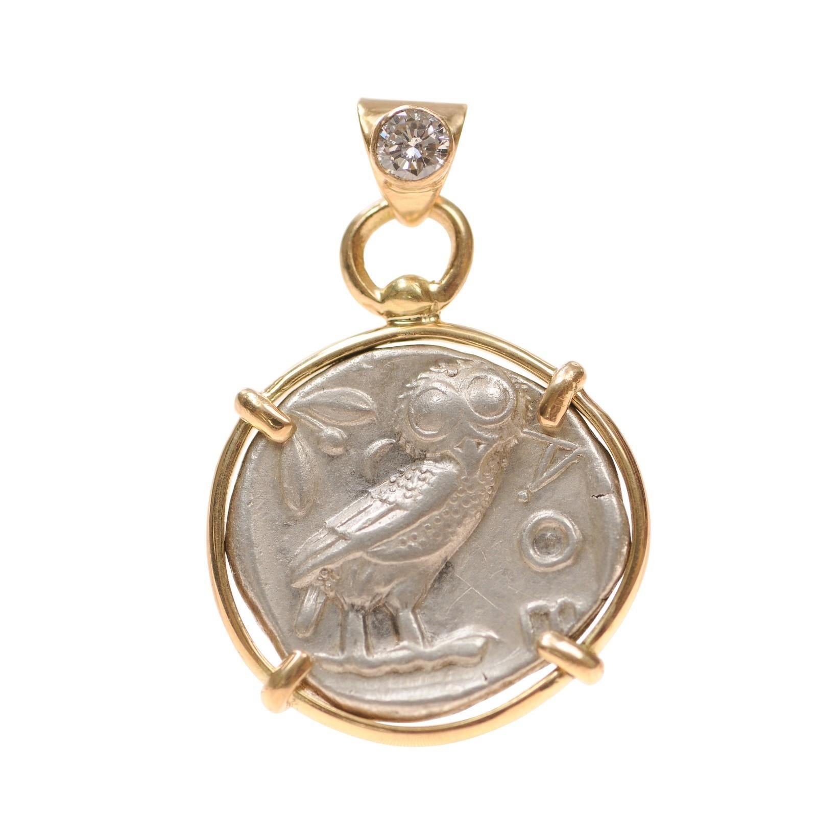 A Silver Tetradrachm coin minted at Attica, Athens in the second half of 5th Century BC. The original coin weighs 17.19 grams and is 25.21 mm wide. This silver coin has 18 karat gold trim around its perimeter, and has four prongs to add some flair