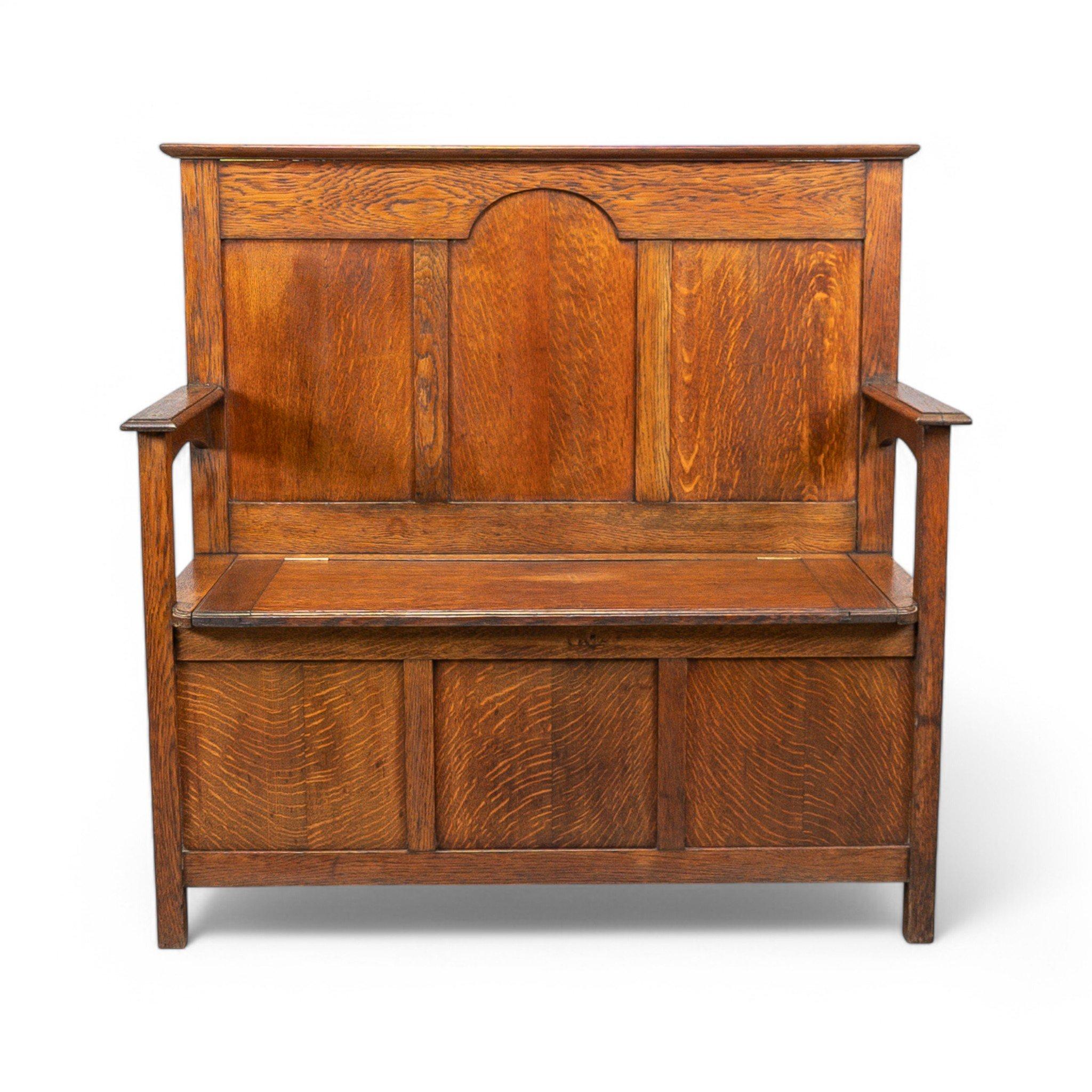Ein einfacher Dielenstuhl aus Eichenholz im Arts-and-Crafts-Stil
Dieser Dielenstuhl mit massiver Rückenlehne und gewölbtem Mittelteil verfügt über einen hochklappbaren Sitz mit einem großen Stauraum darunter.