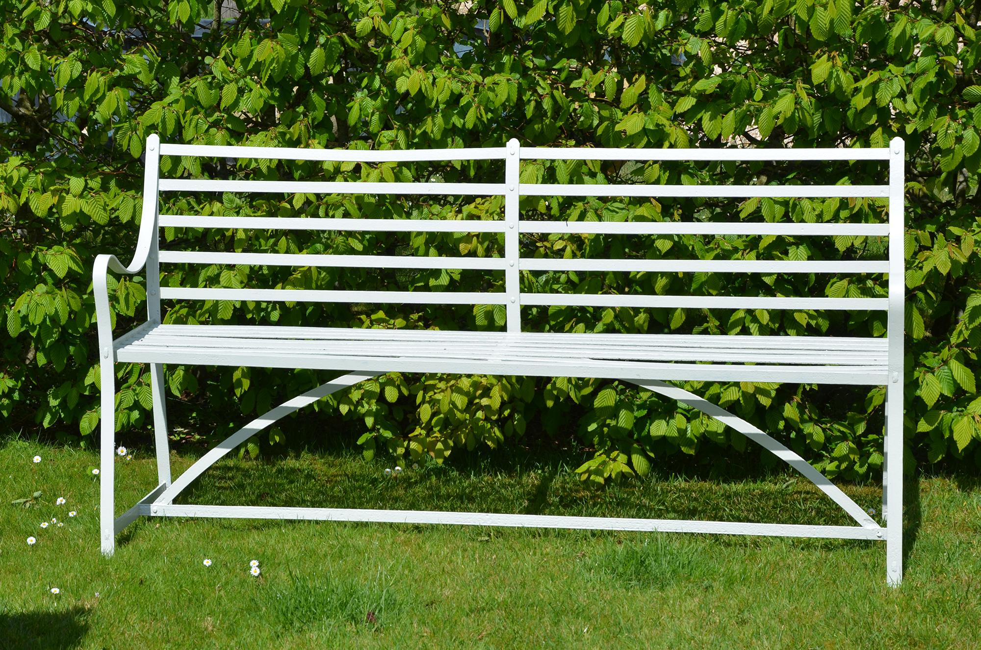 A simple, late 19th century, slat design wrought iron garden bench.
