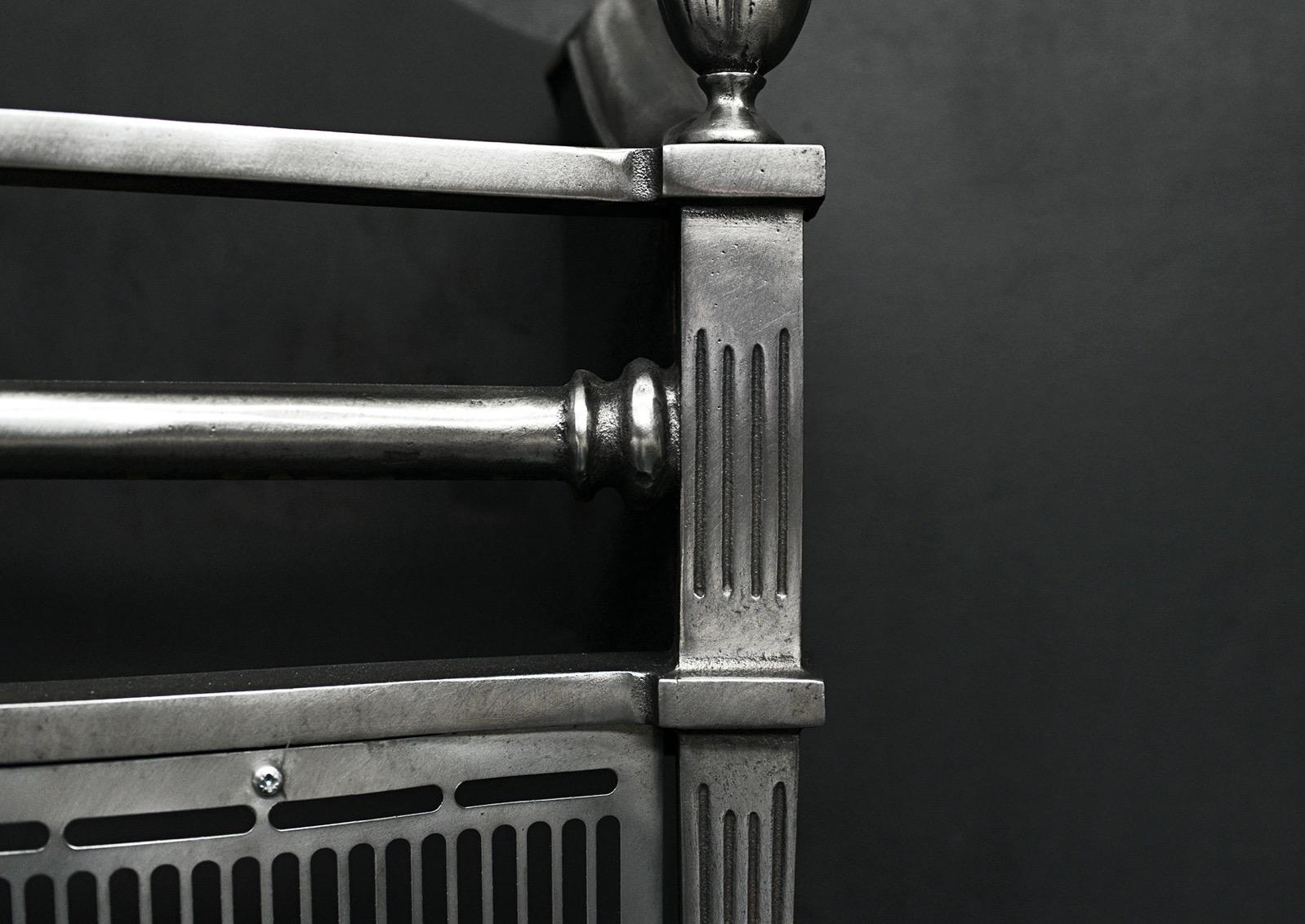 A simple polished steel firegrate. The tapering, fluted legs with urn finials above, bowed fluted fret and shaped burning area. Shaped fireback behind. English, 20th century. 

Width At Front:	560 mm      	22