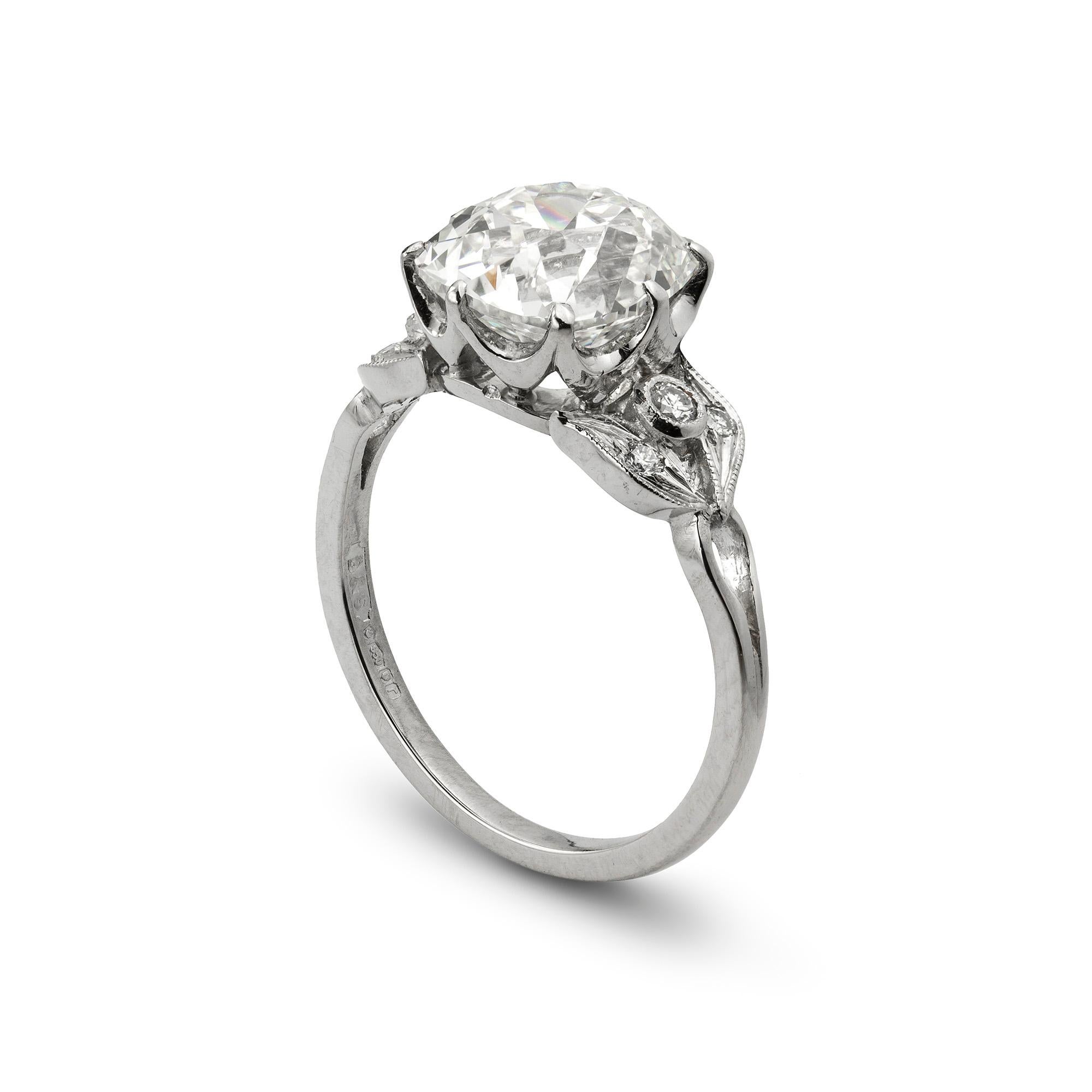 A single stone diamond ring, the old cushion-cut diamond weighing 3.55 carats accompanied by GIA certificate, stating to be of I colour and VS1 clarity, 8 claw-set in white mount with diamond set leaf motif shoulders, from the early 20th century and