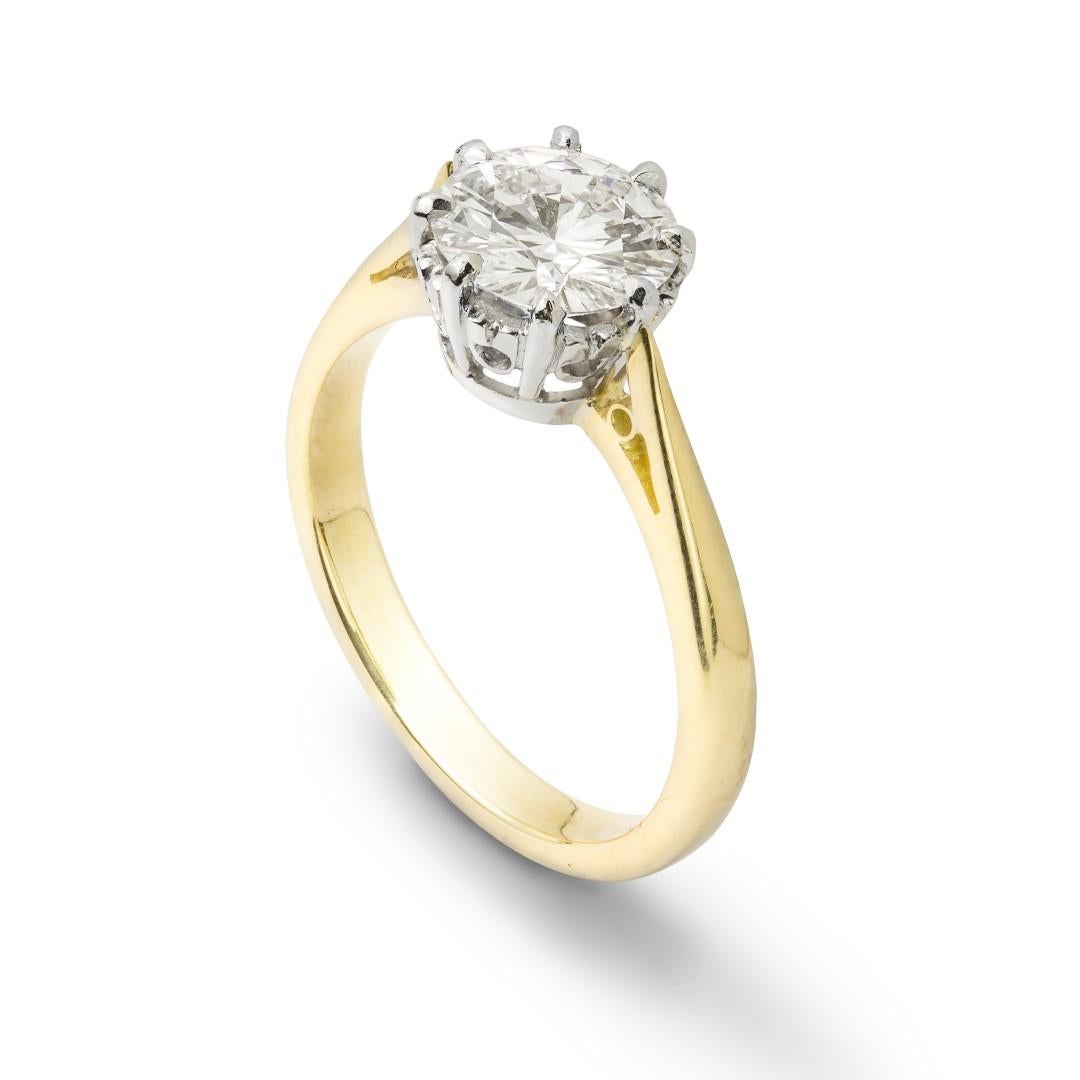 A single stone diamond ring, the round brilliant-cut diamond accompanied by GIA Report, stating the diamond to weigh 1.26 carats to be of E colour and VS1 clarity, set to a platinum scrolled collet to a gold mount with tapering shoulders, hallmarked