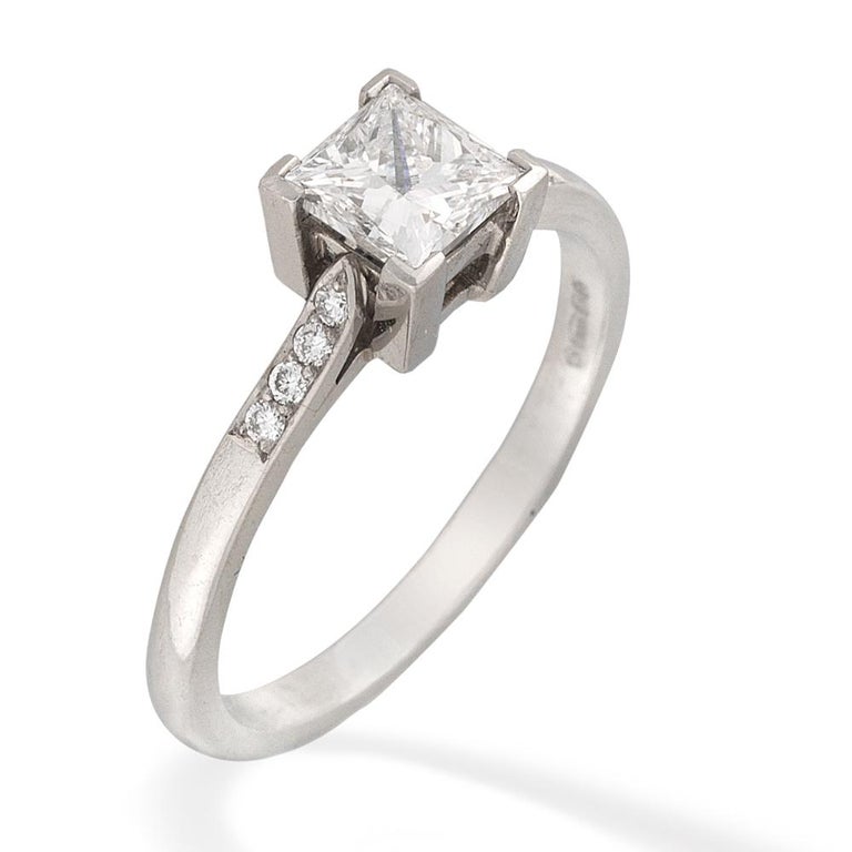 A single stone diamond ring, the princess-cut diamond weighing 0.72 carats, of E colour, VS2 clarity, GIA certificate , four-claw set to a platinum collet, to a tapered D-section shank with diamond-set shoulders, hallmarked platinum, London 2005,