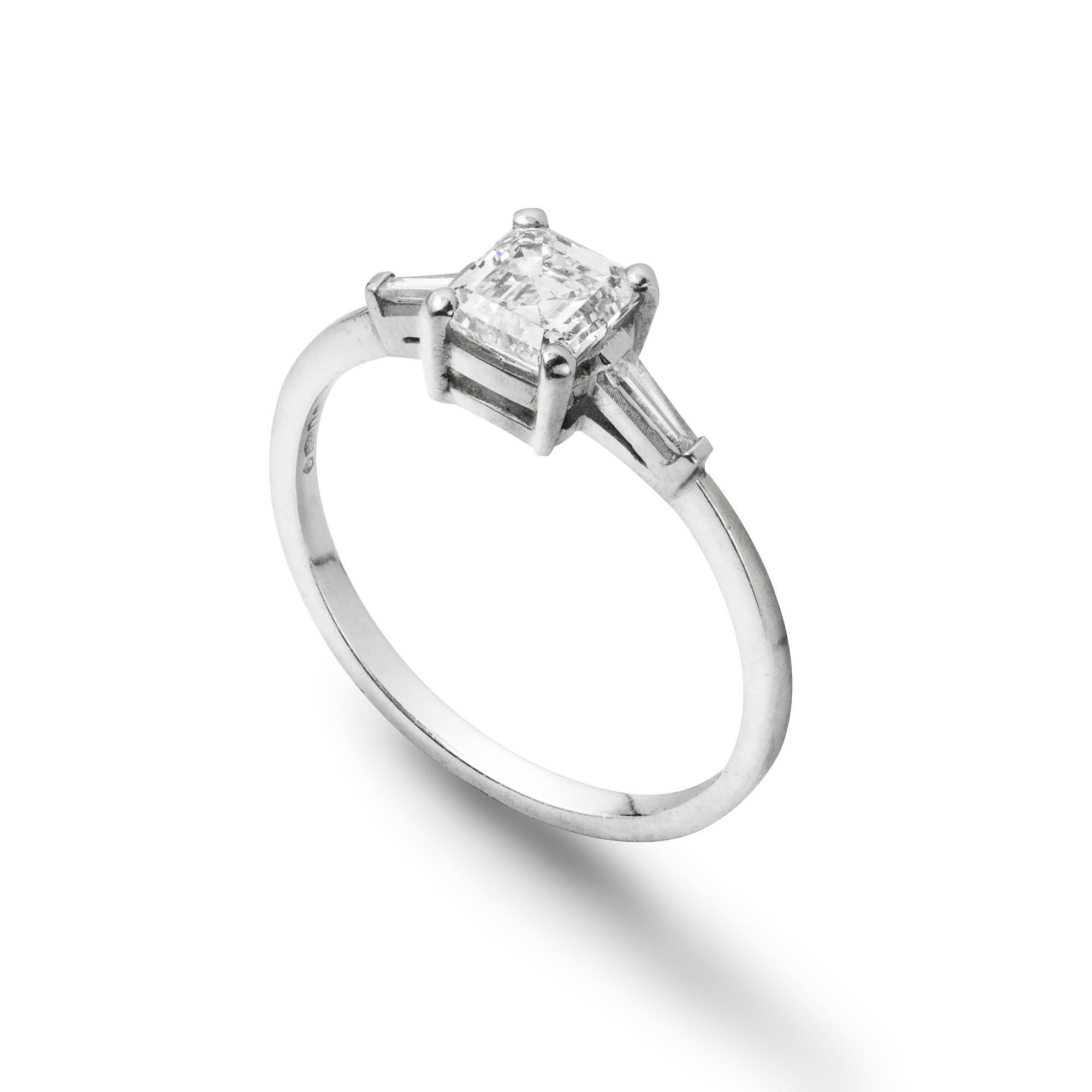 A single stone diamond ring, the Asscher-cut diamond weighing 0.71 carats,accompanied by AnchorCert report, stating to be of G colour, VS2 clarity, set in-between tapered baguette-cut diamond-set shoulders, all claw-set to platinum collets, with