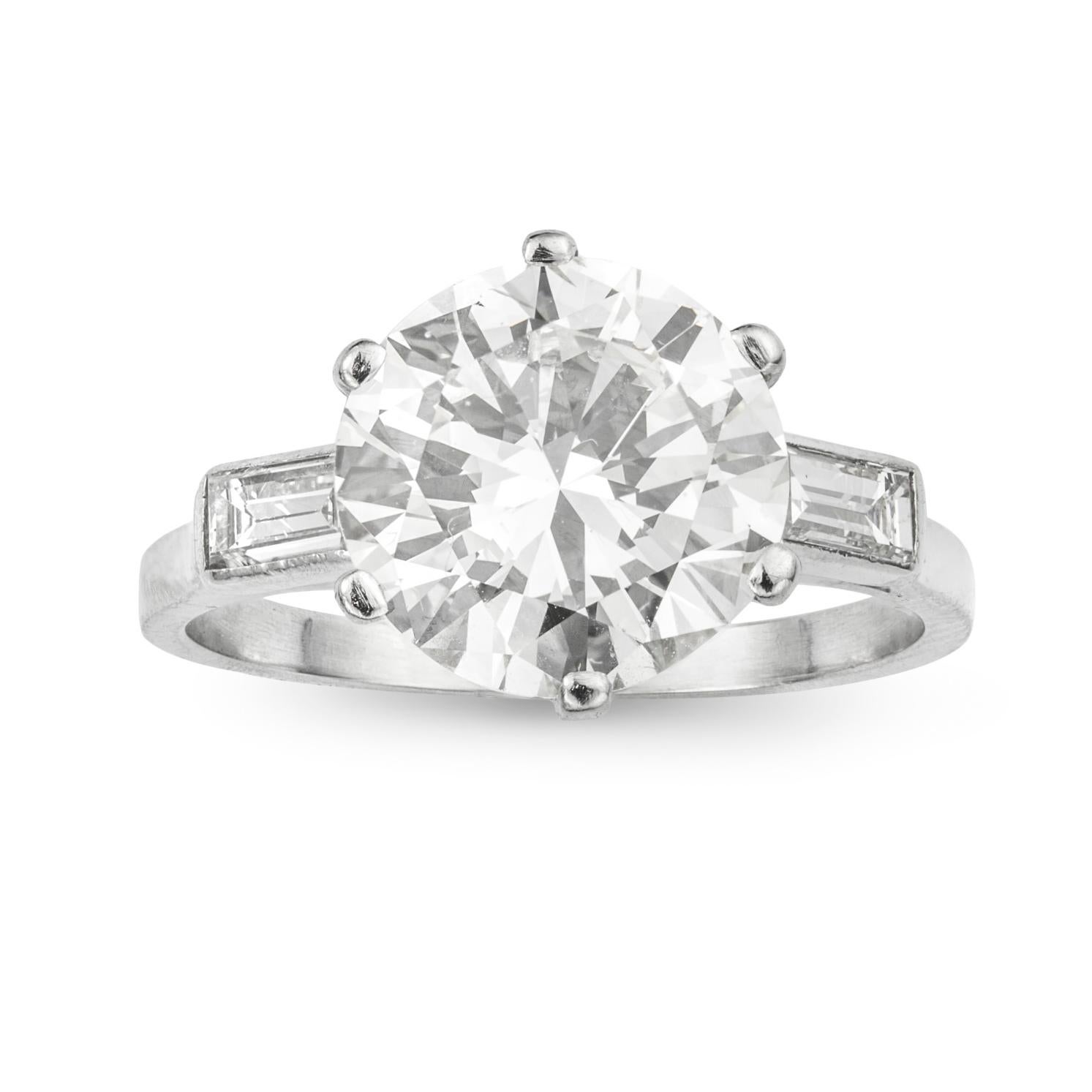 
A single stone diamond ring, the round brilliant-cut diamond weighing 3.44 carats, accompanied by GIA report stating to be of J colour and SI1 clarity, six claw-set in platinum mount between two baguette-cut diamonds estimated to weigh a further