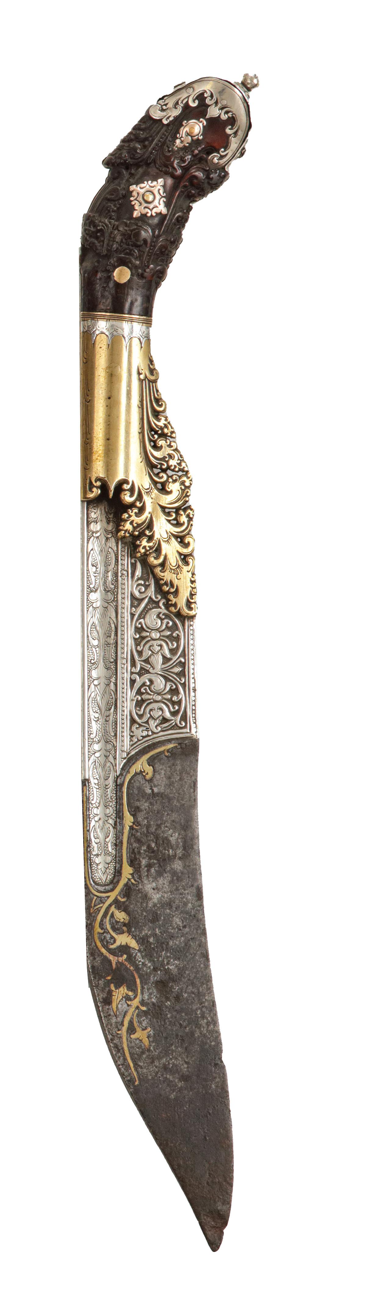 A silver and gold Sinhalese piha-kaetta dagger

Sri Lanka (Ceylon), Kingdom of Kandy, mid-18th century

L. 27 cm
 
The kasthāné is the national sword of Sri Lanka. It seems to have emerged in the 16th century following the first contact with