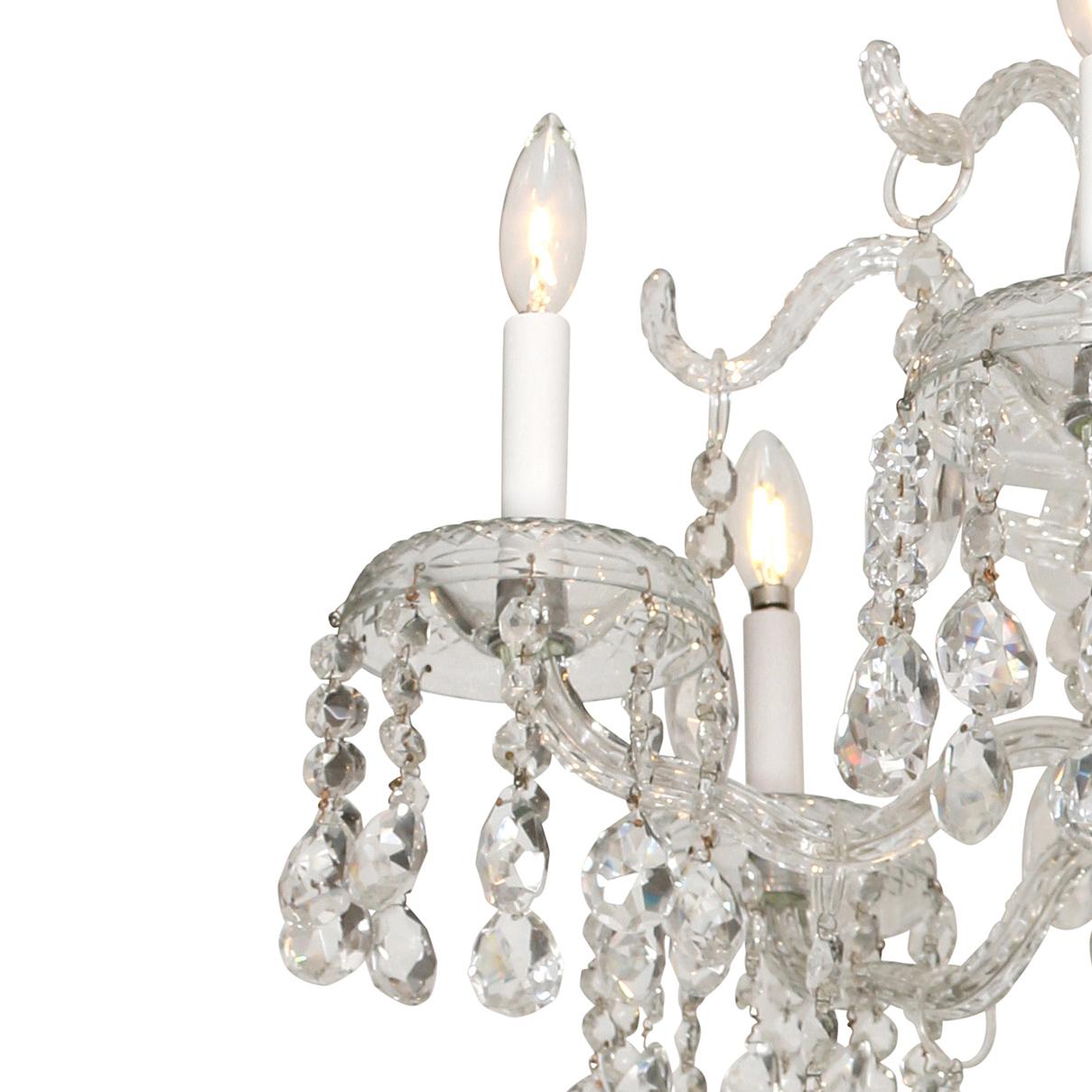 A fanciful six-arm chandelier with four tiers decorated with crystal prisms, beads and balls. This gem will add a touch of fun and glamour to any space!