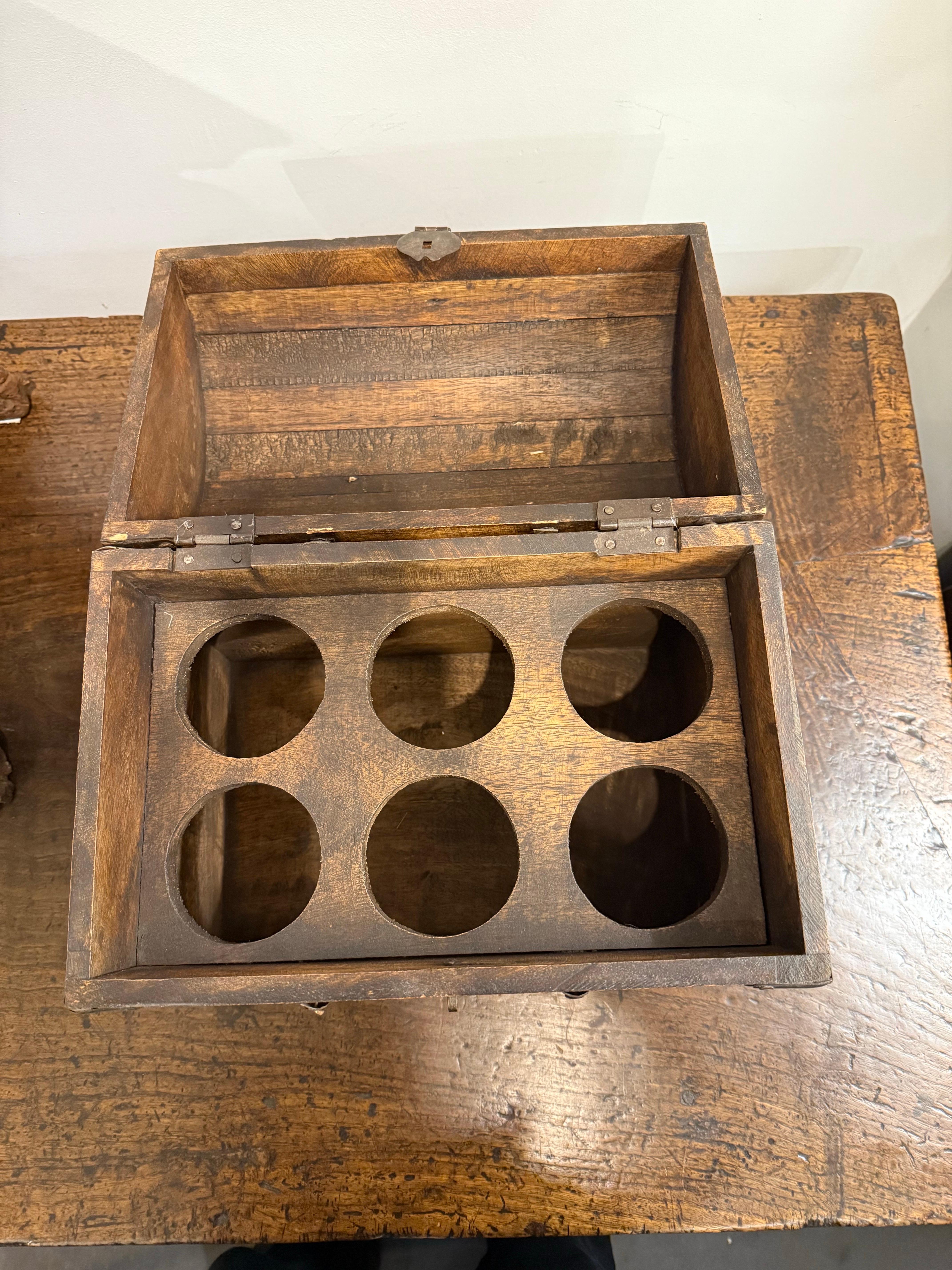 A Six Bottle Wine Chest, Early 20th Century

The domed hinged lid opening to an interior with a wooden six bottle rack, a latch to the front and a pair of iron drop handles to either side.

Provenance: Private Australian